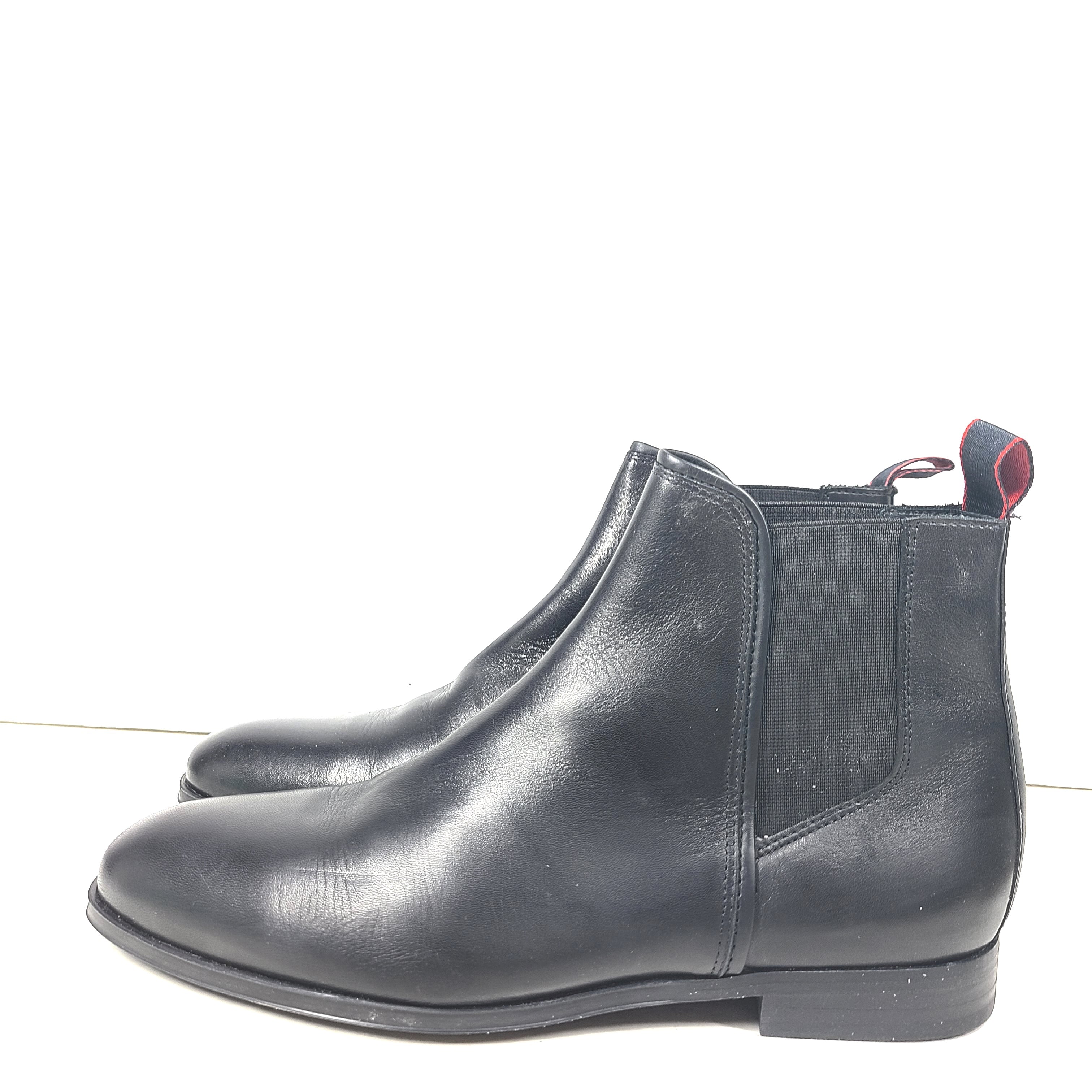 Black leather Chelsea boots by Hugo Boss with a sleek ankle silhouette and branded insole.