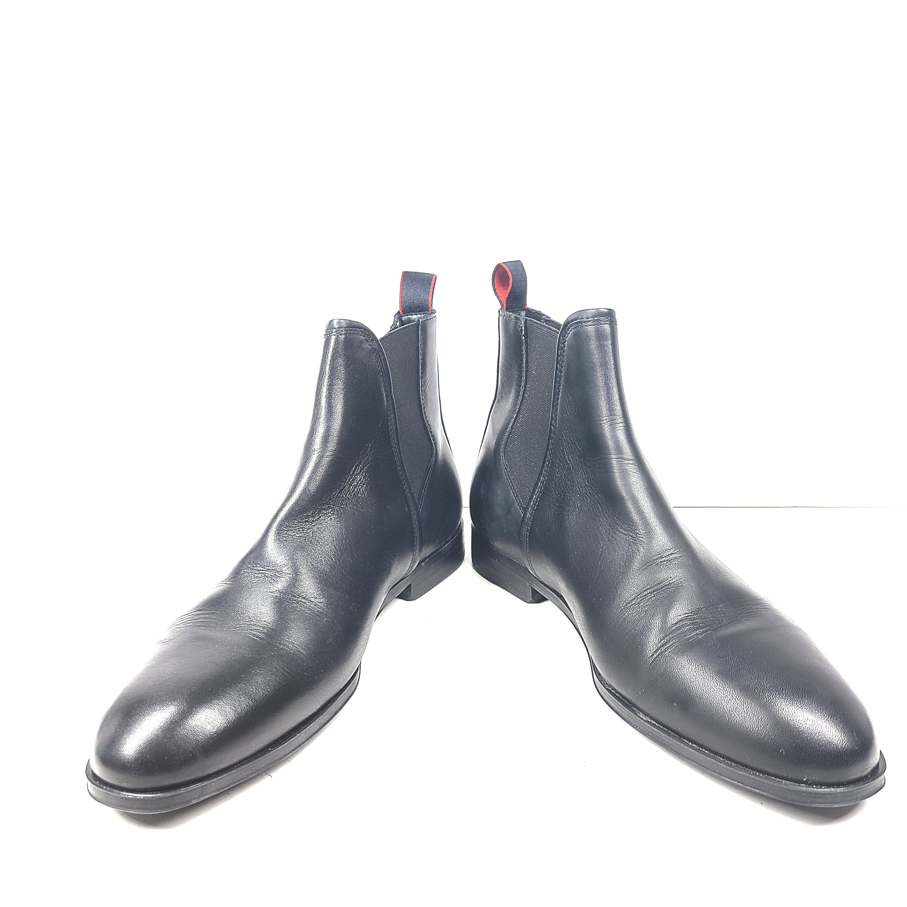 Black leather Chelsea boots by Hugo Boss with a sleek ankle silhouette and branded insole.