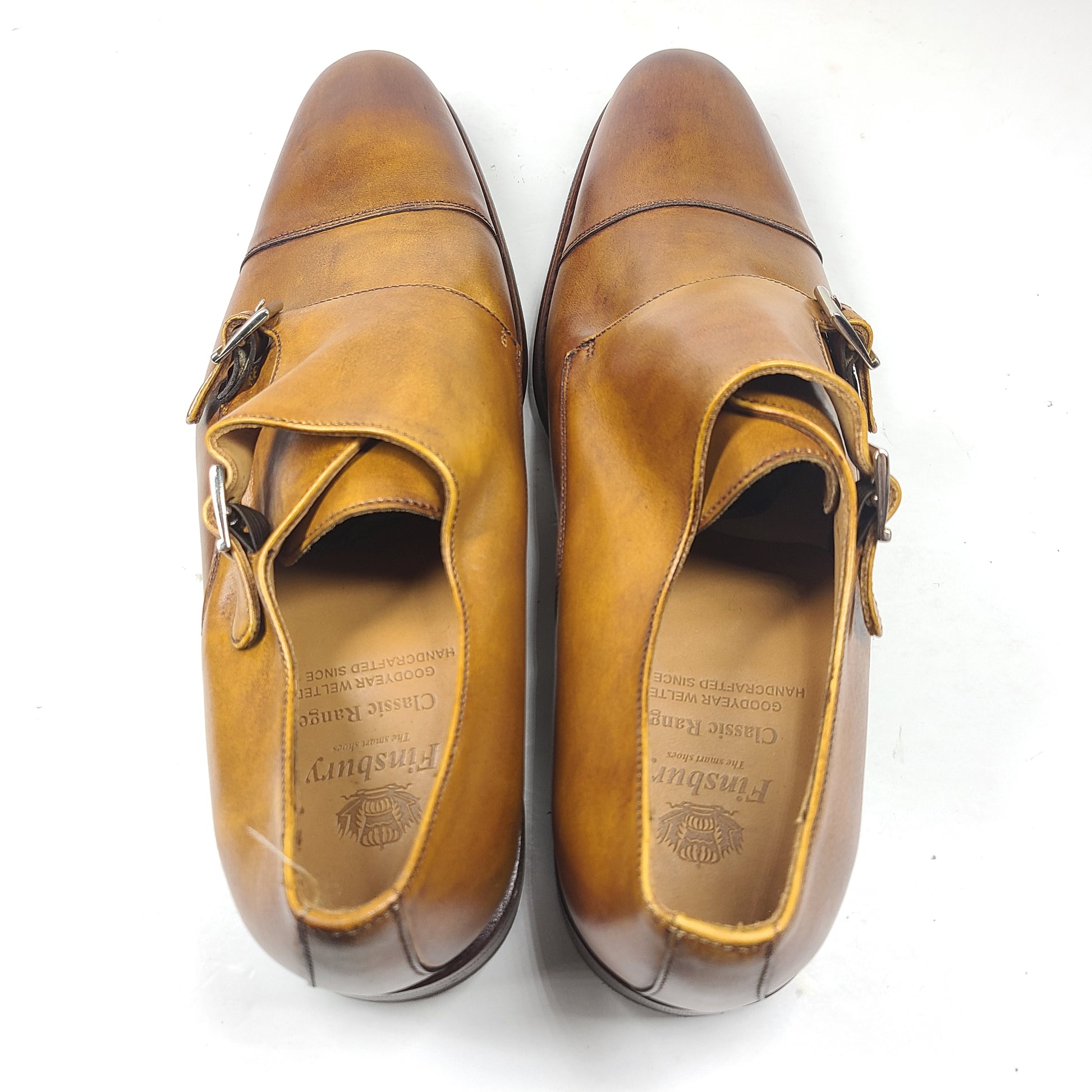 Brown Goodyear-welted leather dress shoes with a refined rounded silhouette and stacked heel.