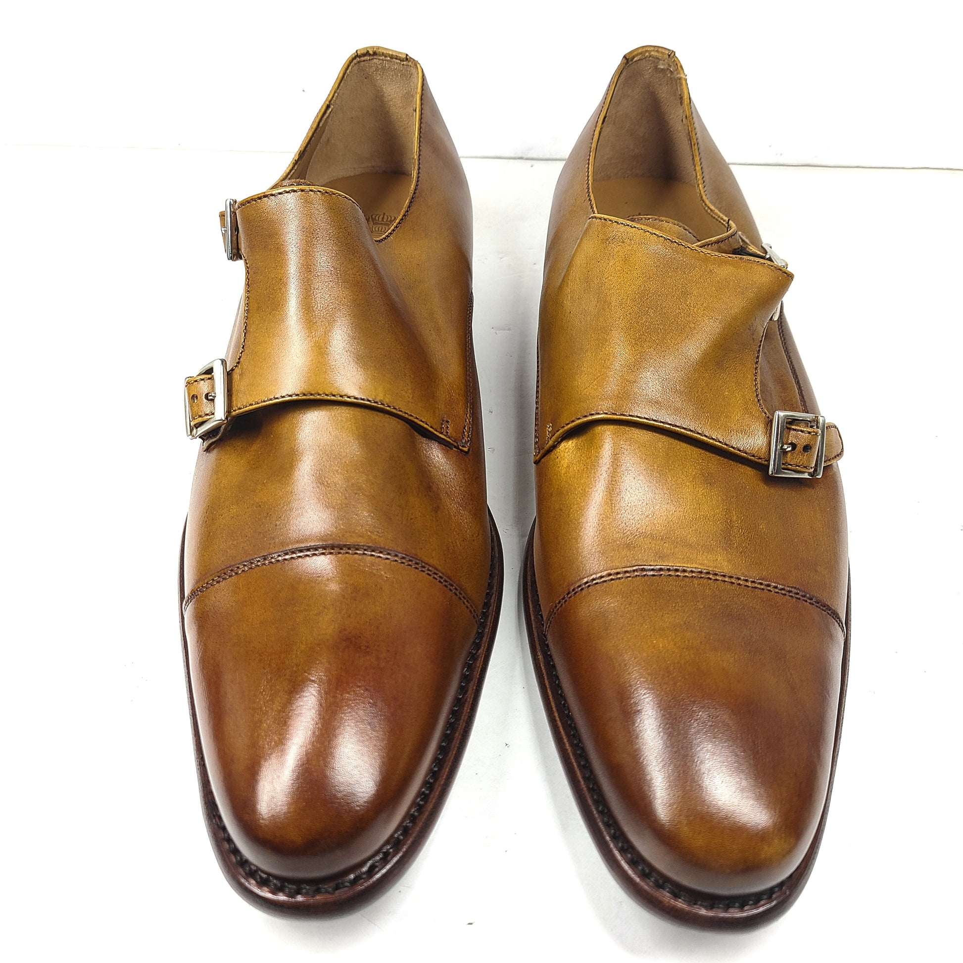 Brown Goodyear-welted leather dress shoes with a refined rounded silhouette and stacked heel.