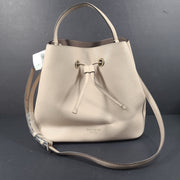 Beige Kate Spade handbag with intact price tag and protective plastic on the straps.