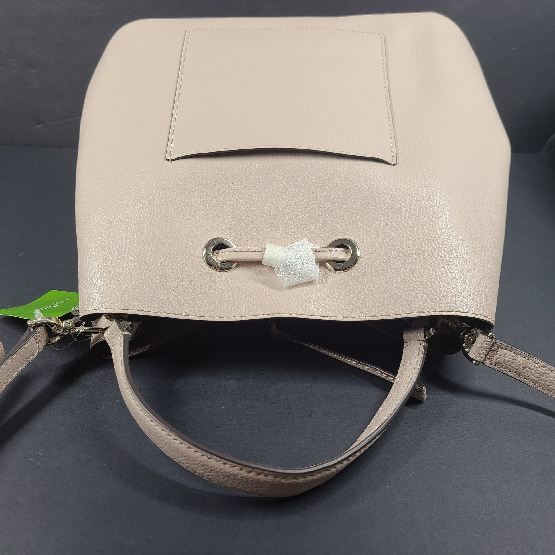 Beige Kate Spade handbag with intact price tag and protective plastic on the straps.