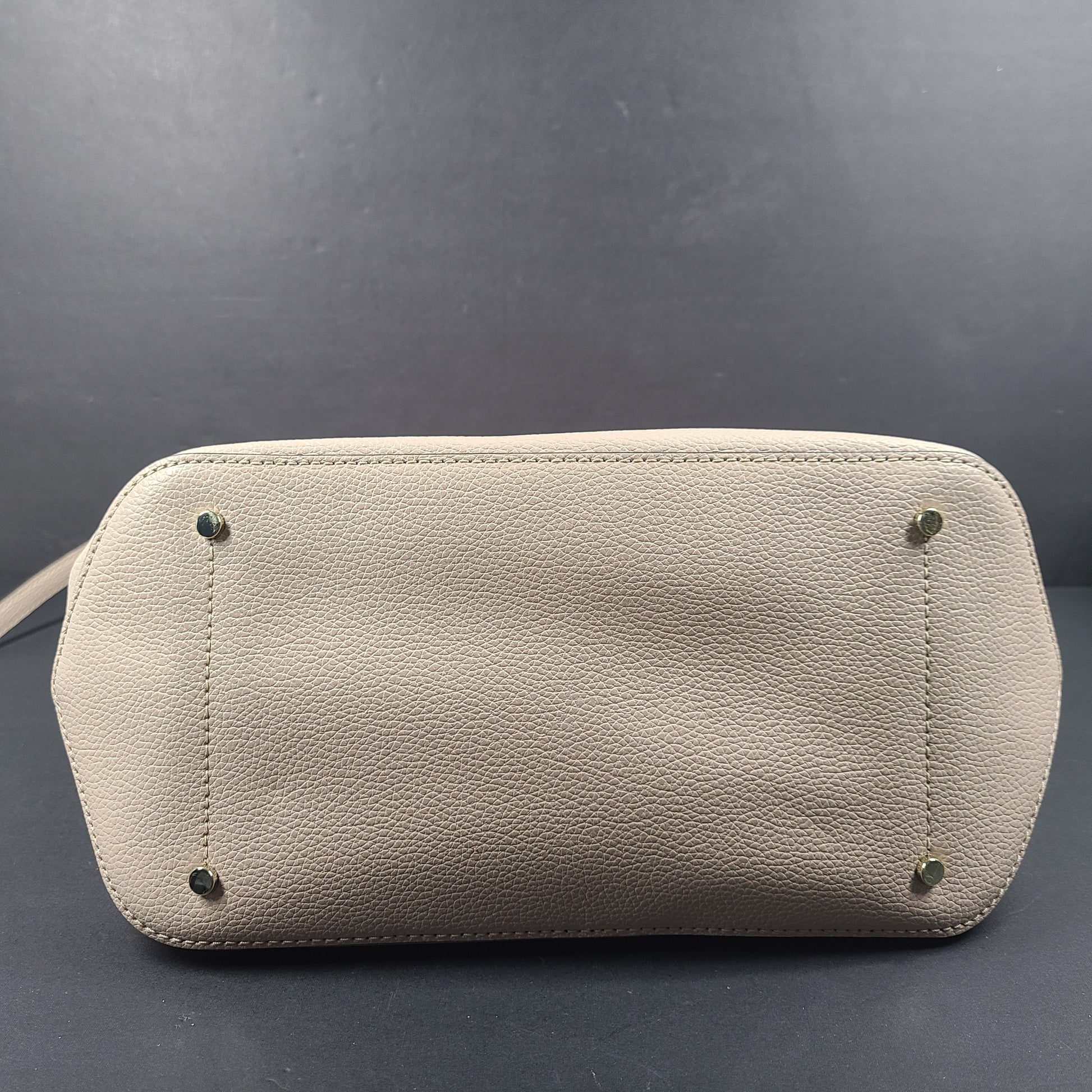 Beige Kate Spade handbag with intact price tag and protective plastic on the straps.