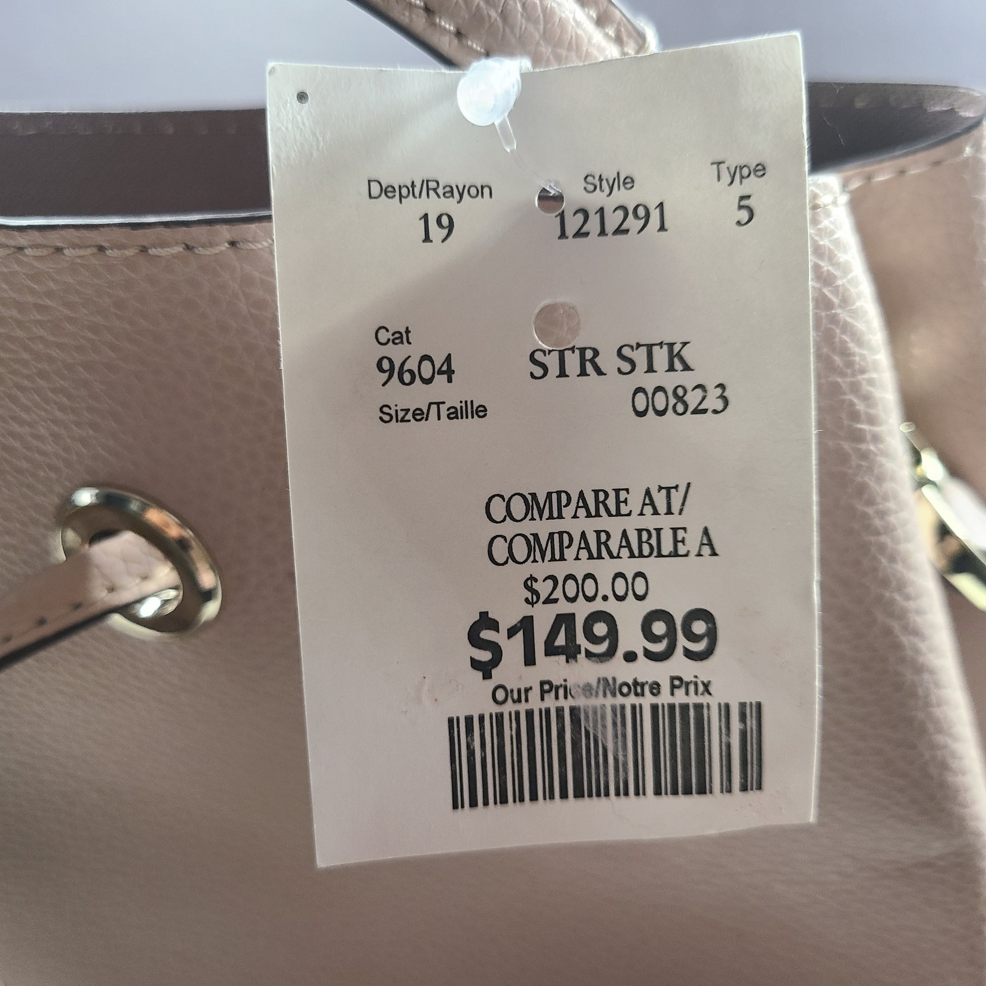 Beige Kate Spade handbag with intact price tag and protective plastic on the straps.