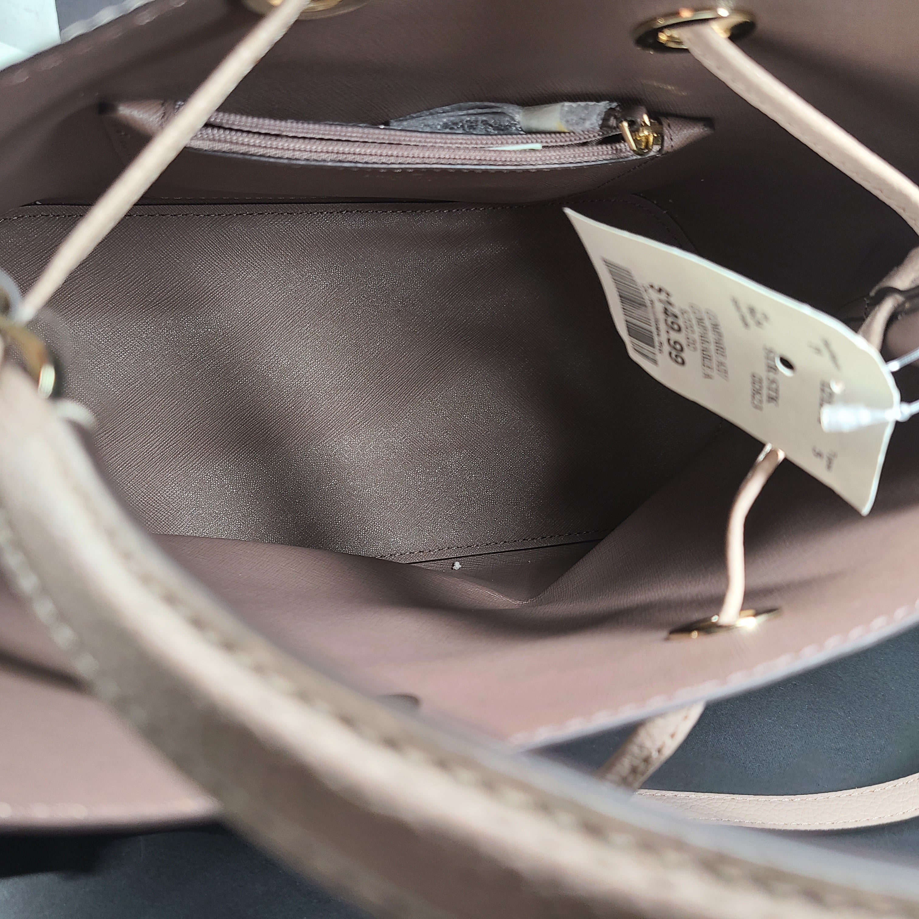 Beige Kate Spade handbag with intact price tag and protective plastic on the straps.