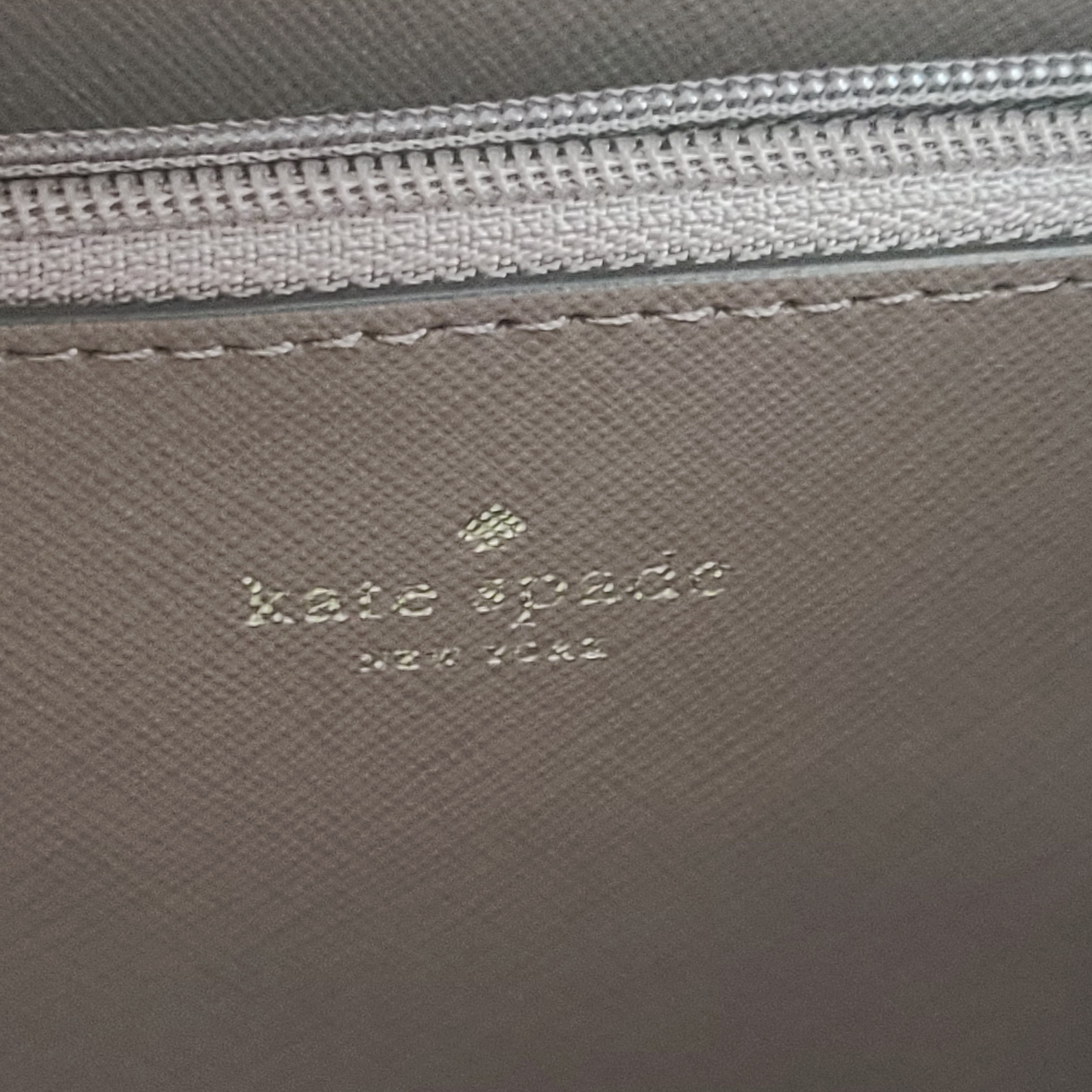 Beige Kate Spade handbag with intact price tag and protective plastic on the straps.