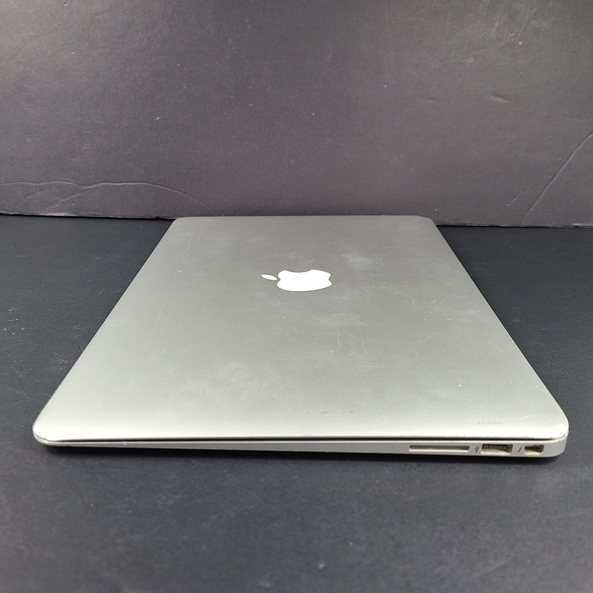 Silver Apple MacBook Air A1466 with body wear and a damaged screen, sold with a charger.