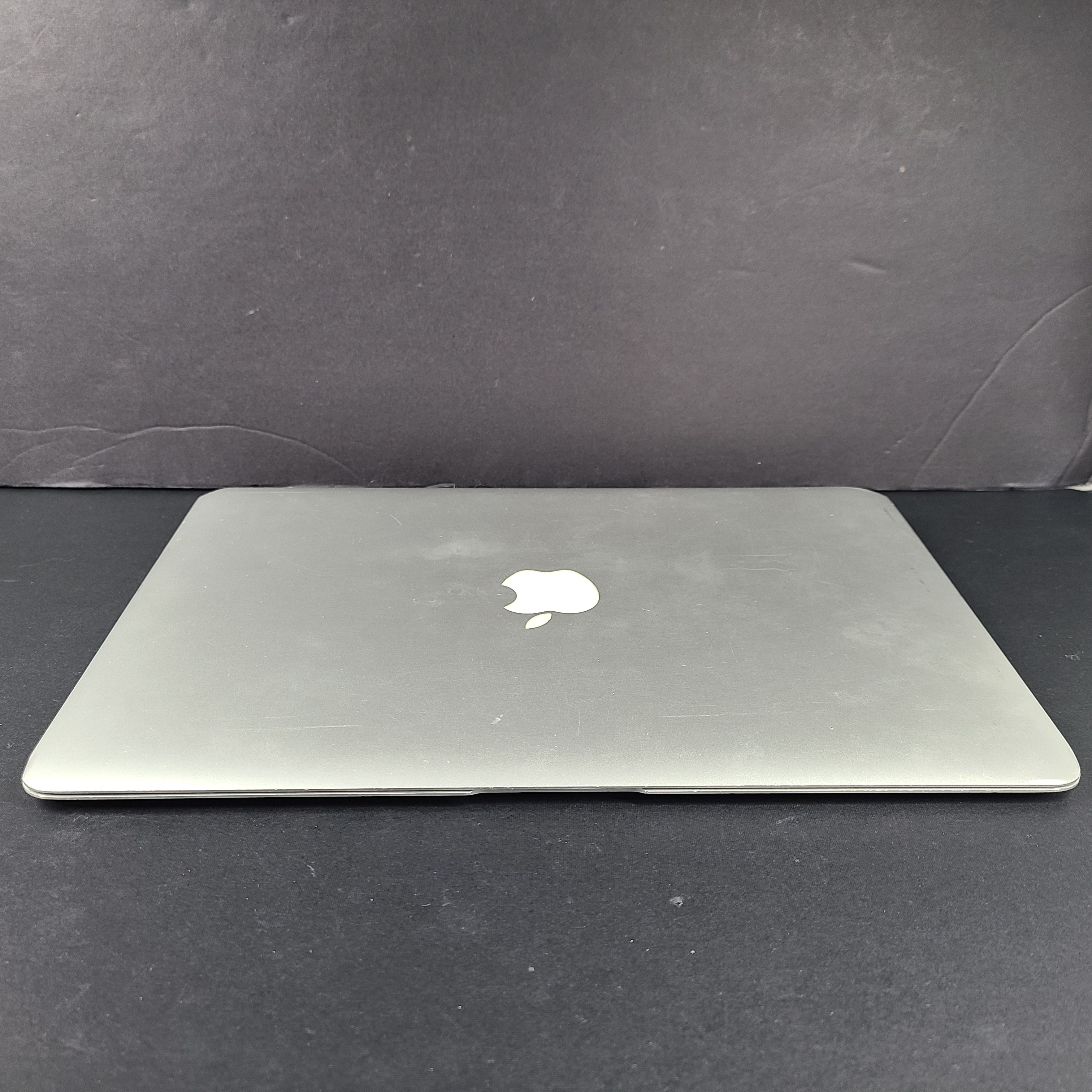Silver Apple MacBook Air A1466 with body wear and a damaged screen, sold with a charger.