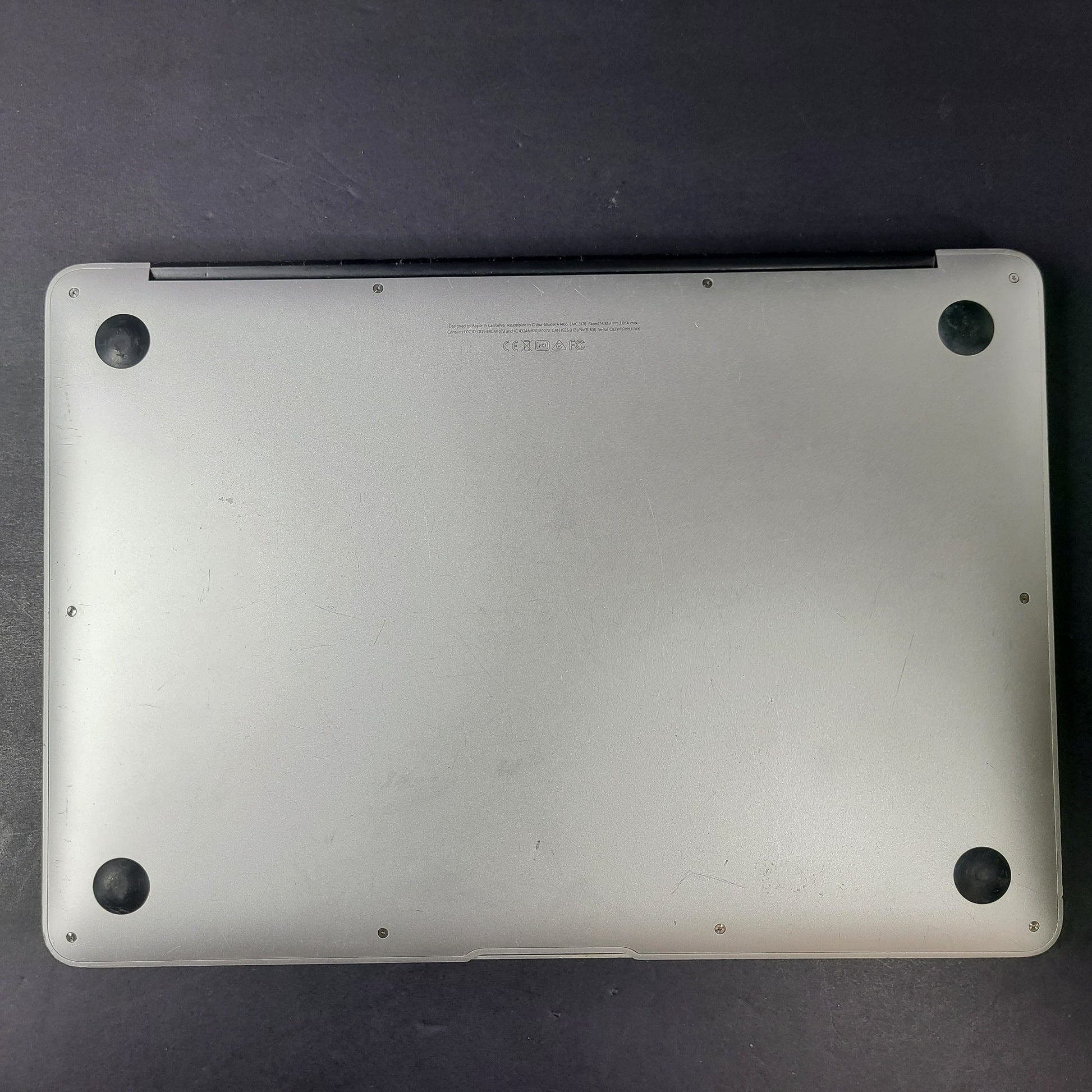 Silver Apple MacBook Air A1466 with body wear and a damaged screen, sold with a charger.
