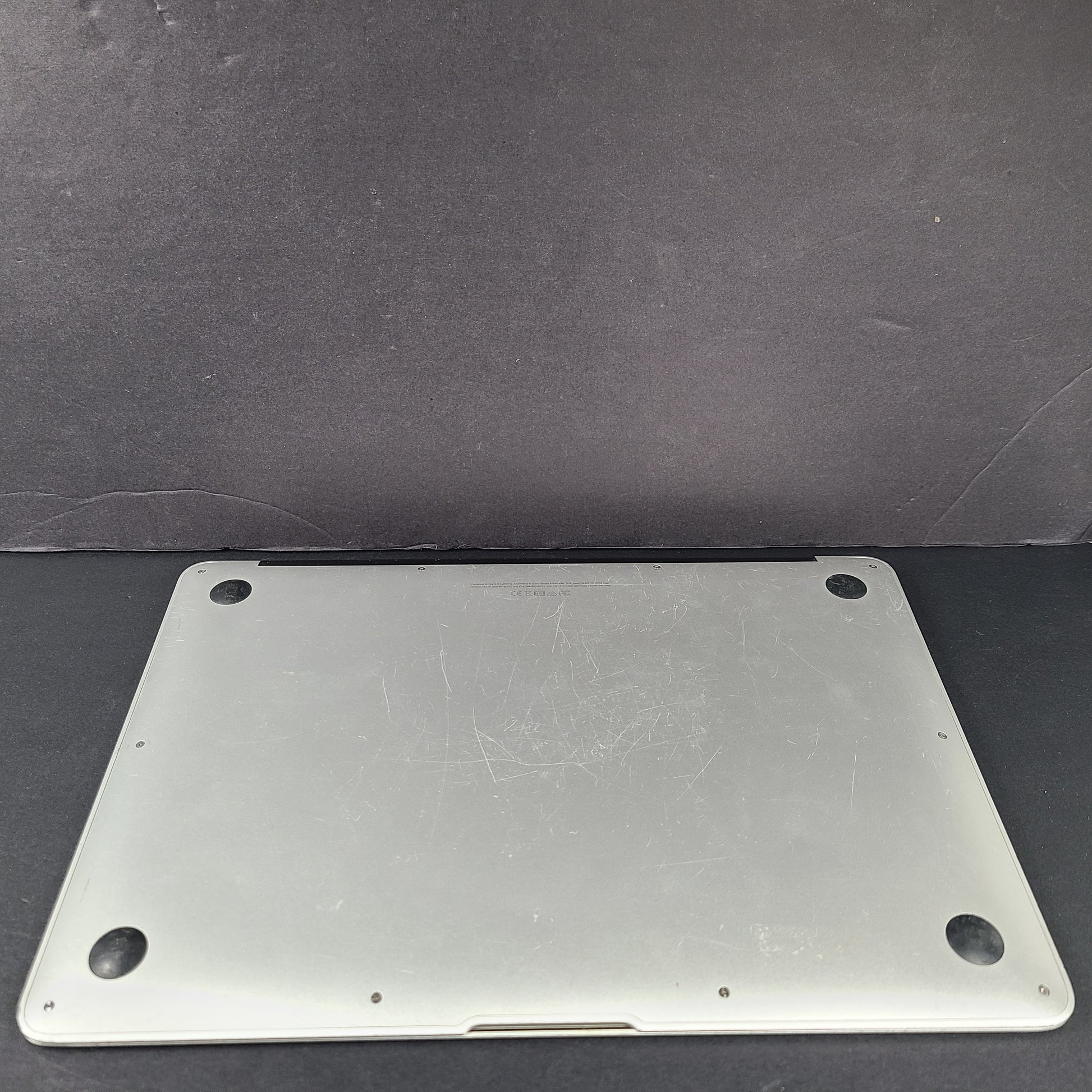 Silver Apple MacBook Air A1466 with body wear and a damaged screen, sold with a charger.