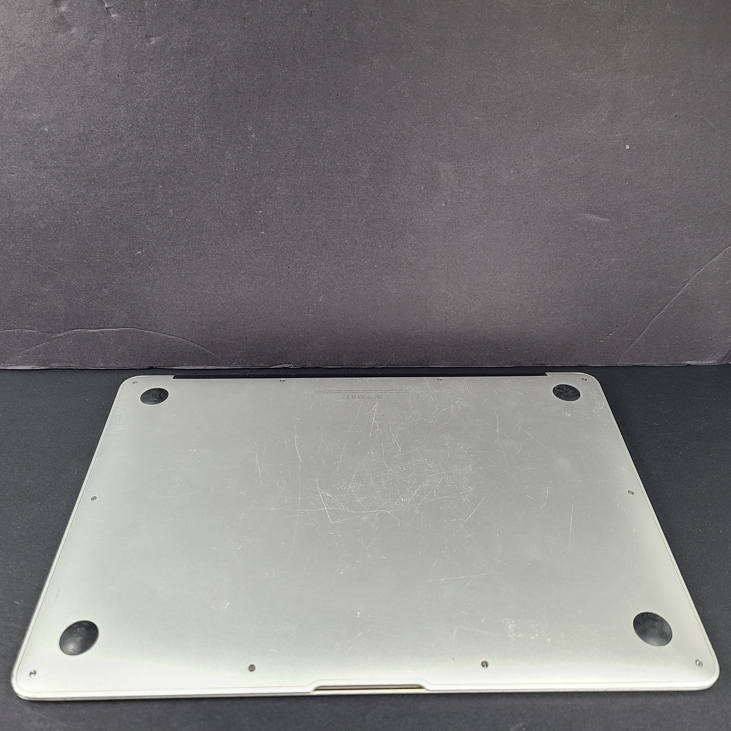 Silver Apple MacBook Air A1466 with body wear and a damaged screen, sold with a charger.