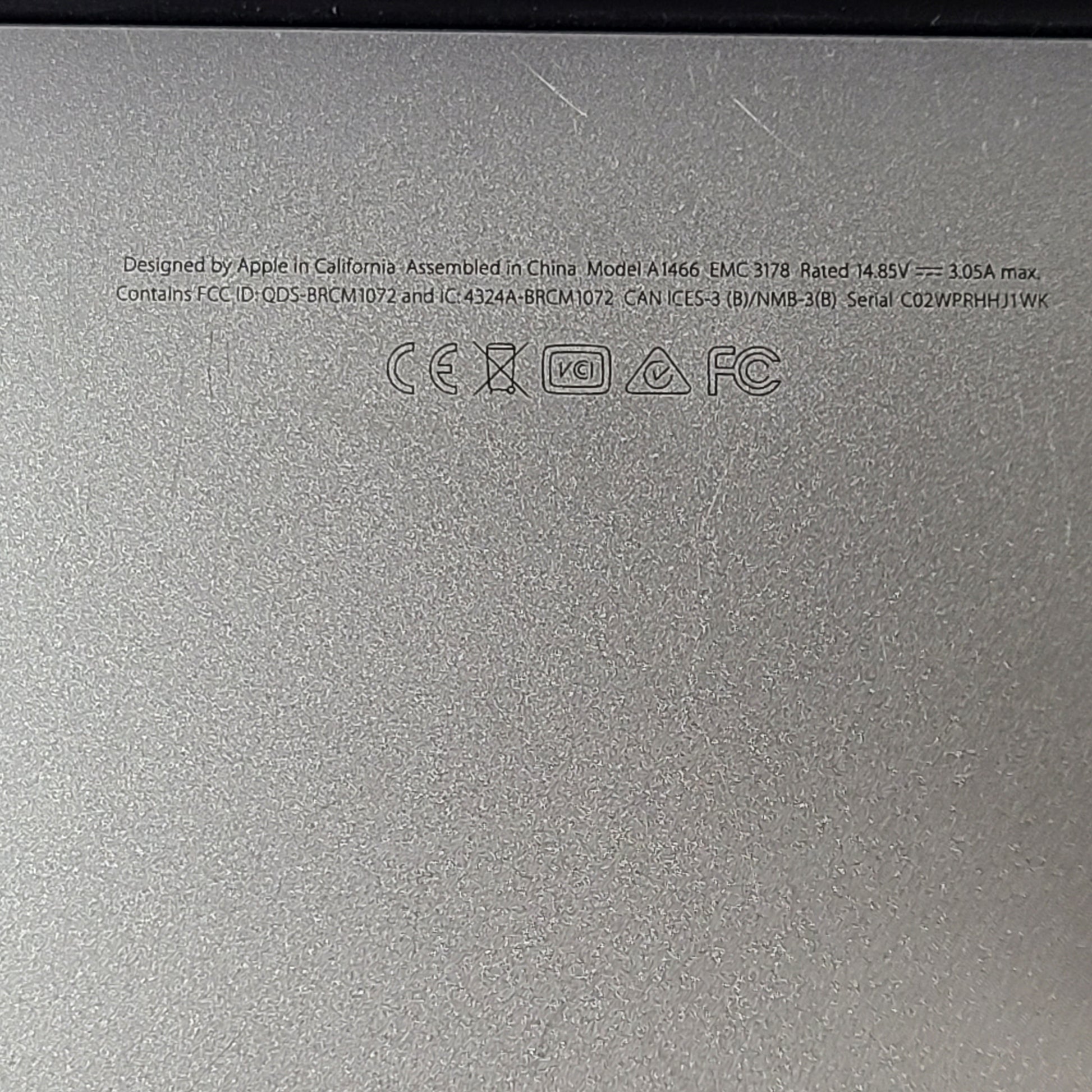 Silver Apple MacBook Air A1466 with body wear and a damaged screen, sold with a charger.