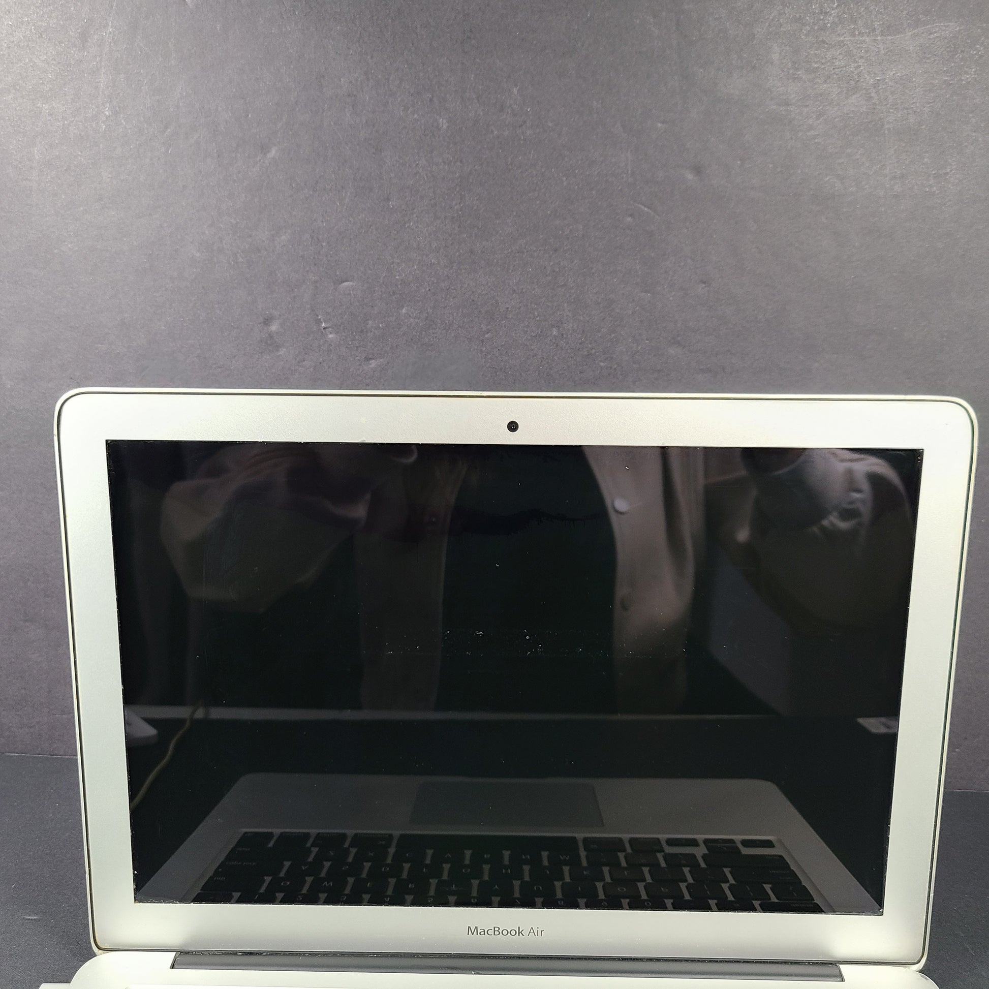 Silver Apple MacBook Air A1466 with body wear and a damaged screen, sold with a charger.