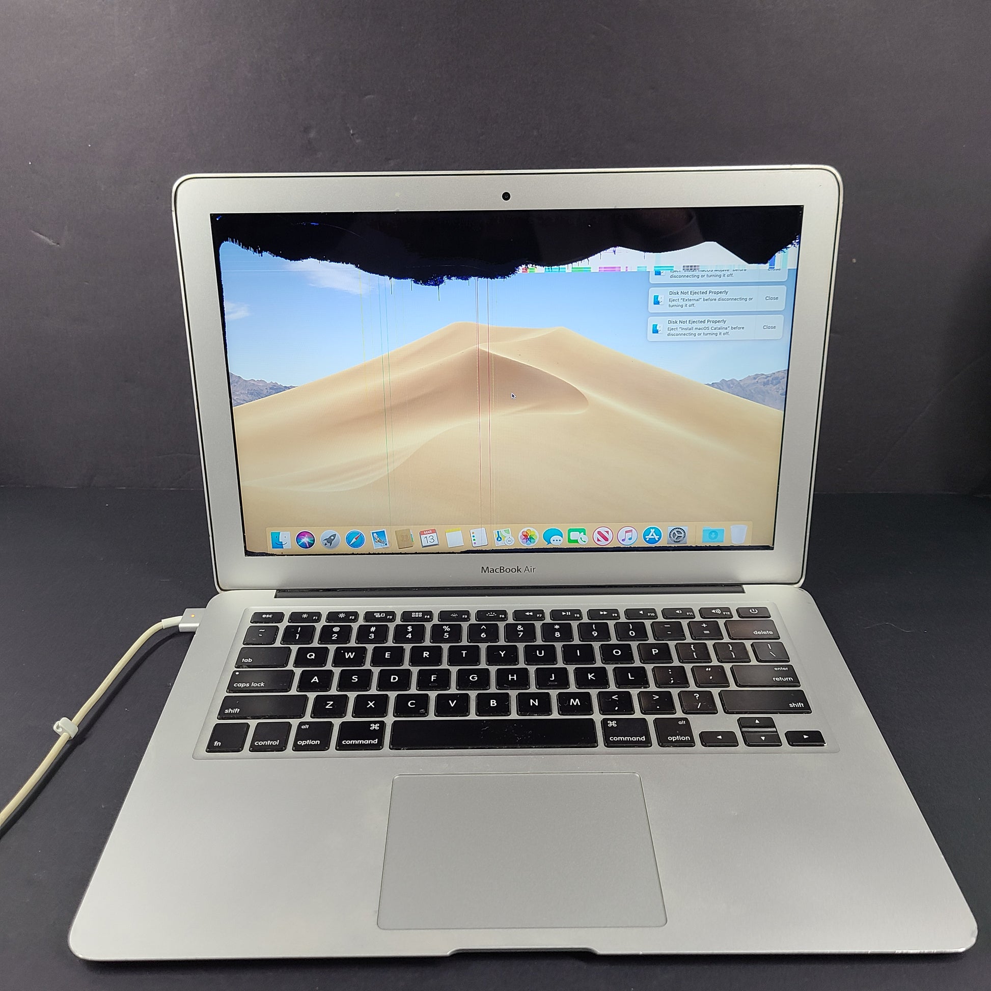 Silver Apple MacBook Air A1466 with body wear and a damaged screen, sold with a charger.