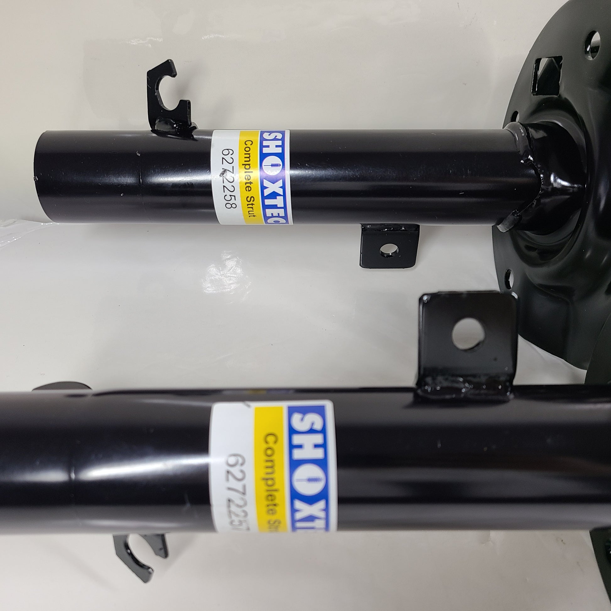 Two Shoxtec Complete Struts in black with mounting accessories for vehicle suspension replacement.