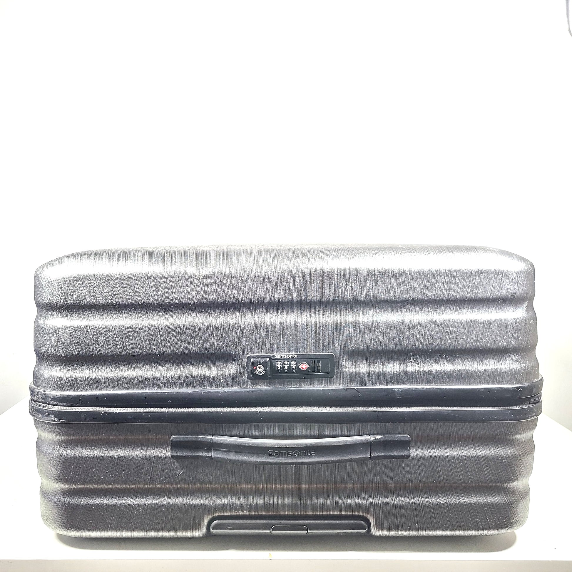 Black Samsonite Spinner 81/30 suitcase with scuffing on wheels and a clean interior.