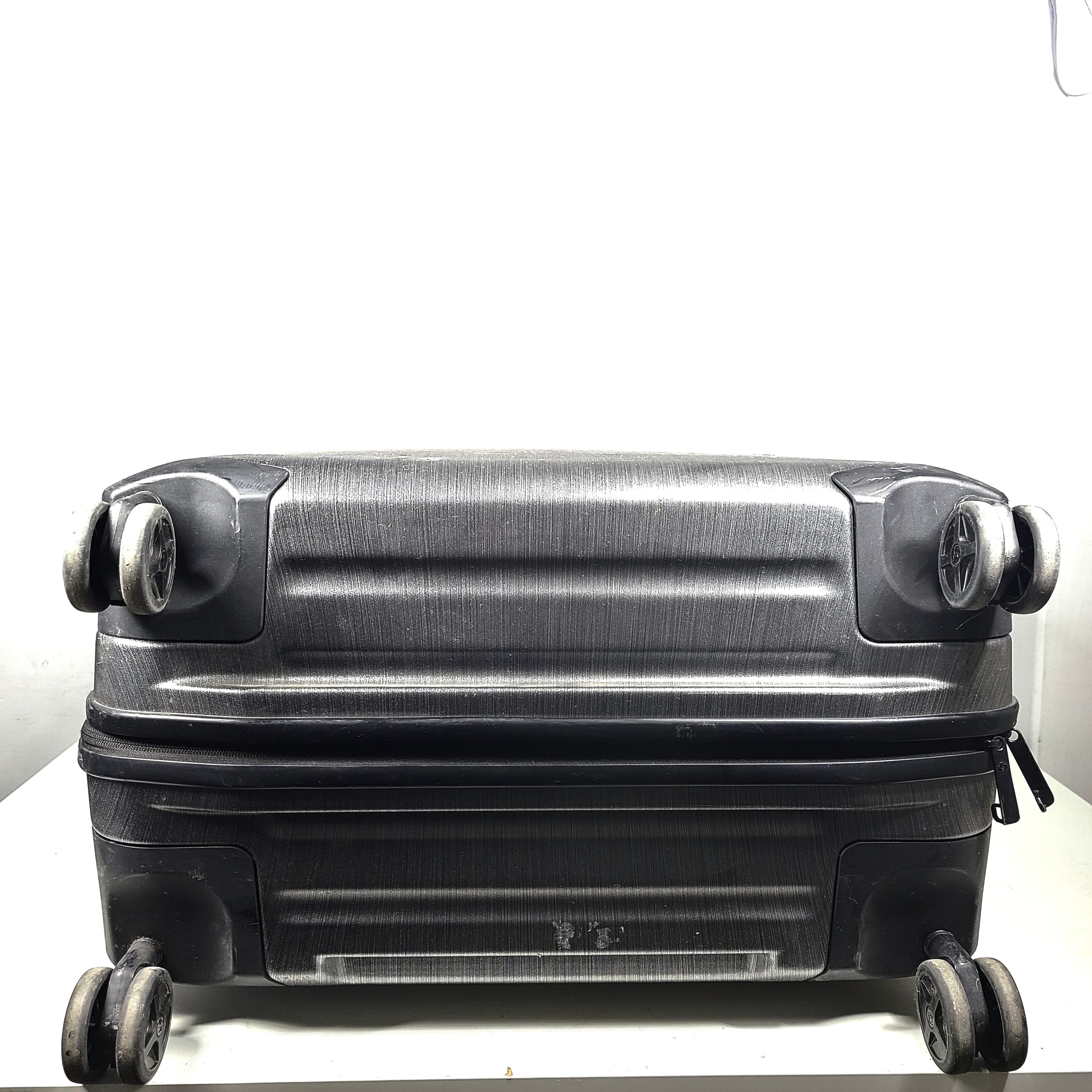 Black Samsonite Spinner 81/30 suitcase with scuffing on wheels and a clean interior.