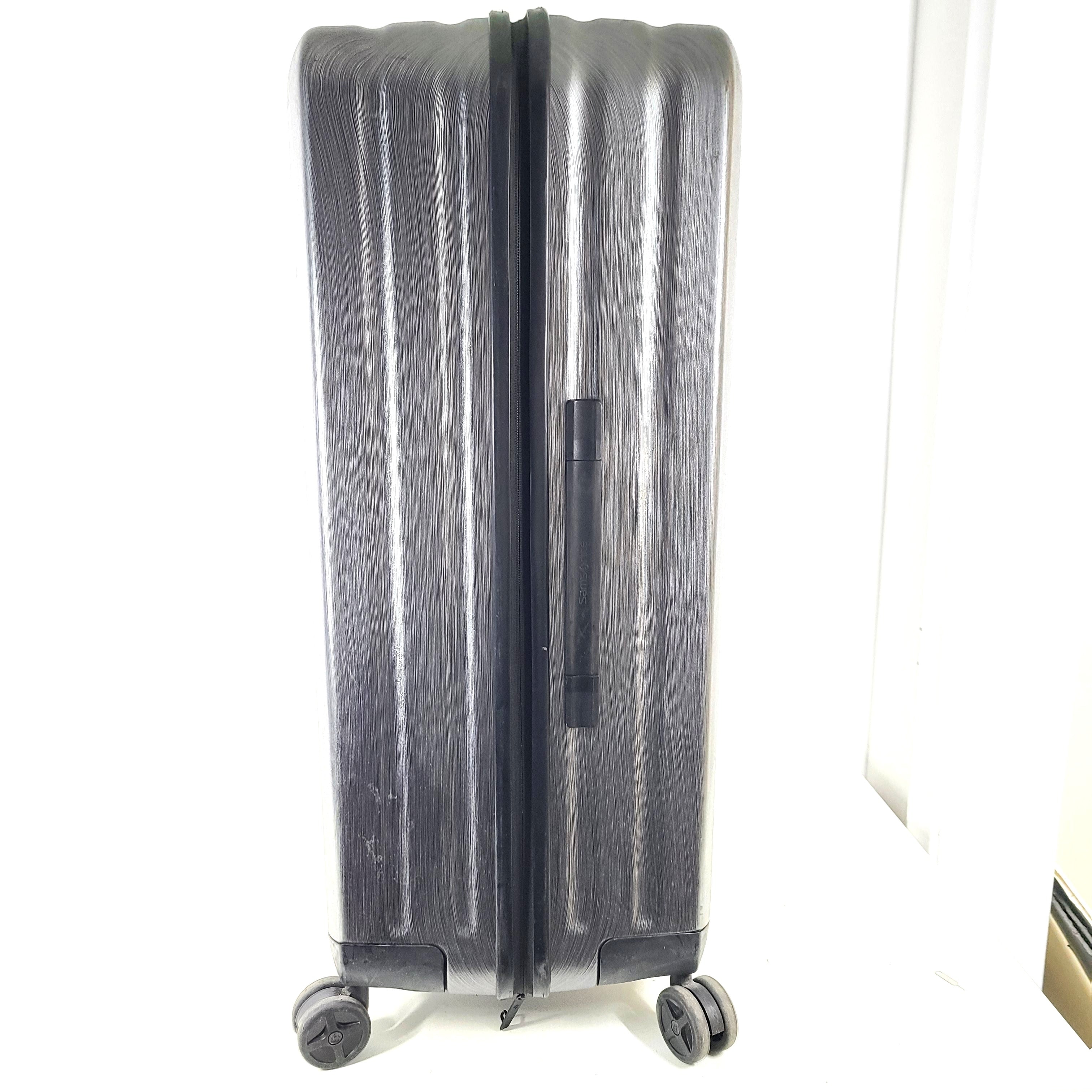 Black Samsonite Spinner 81/30 suitcase with scuffing on wheels and a clean interior.