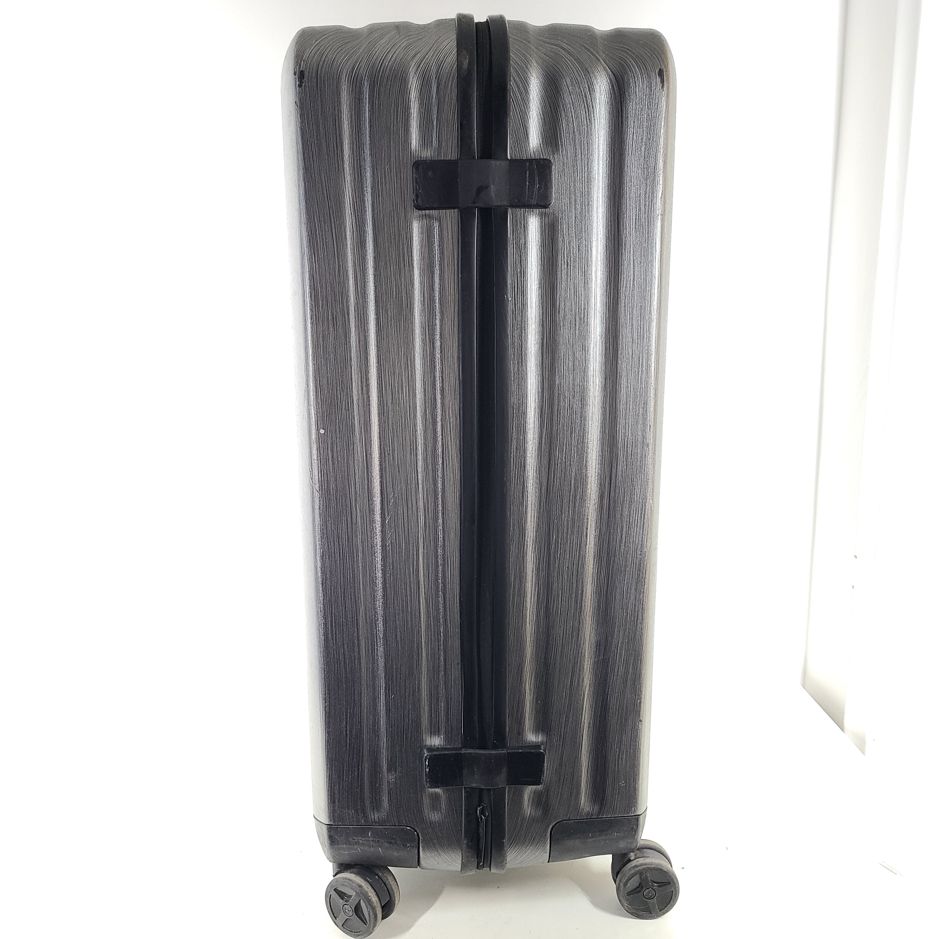 Black Samsonite Spinner 81/30 suitcase with scuffing on wheels and a clean interior.