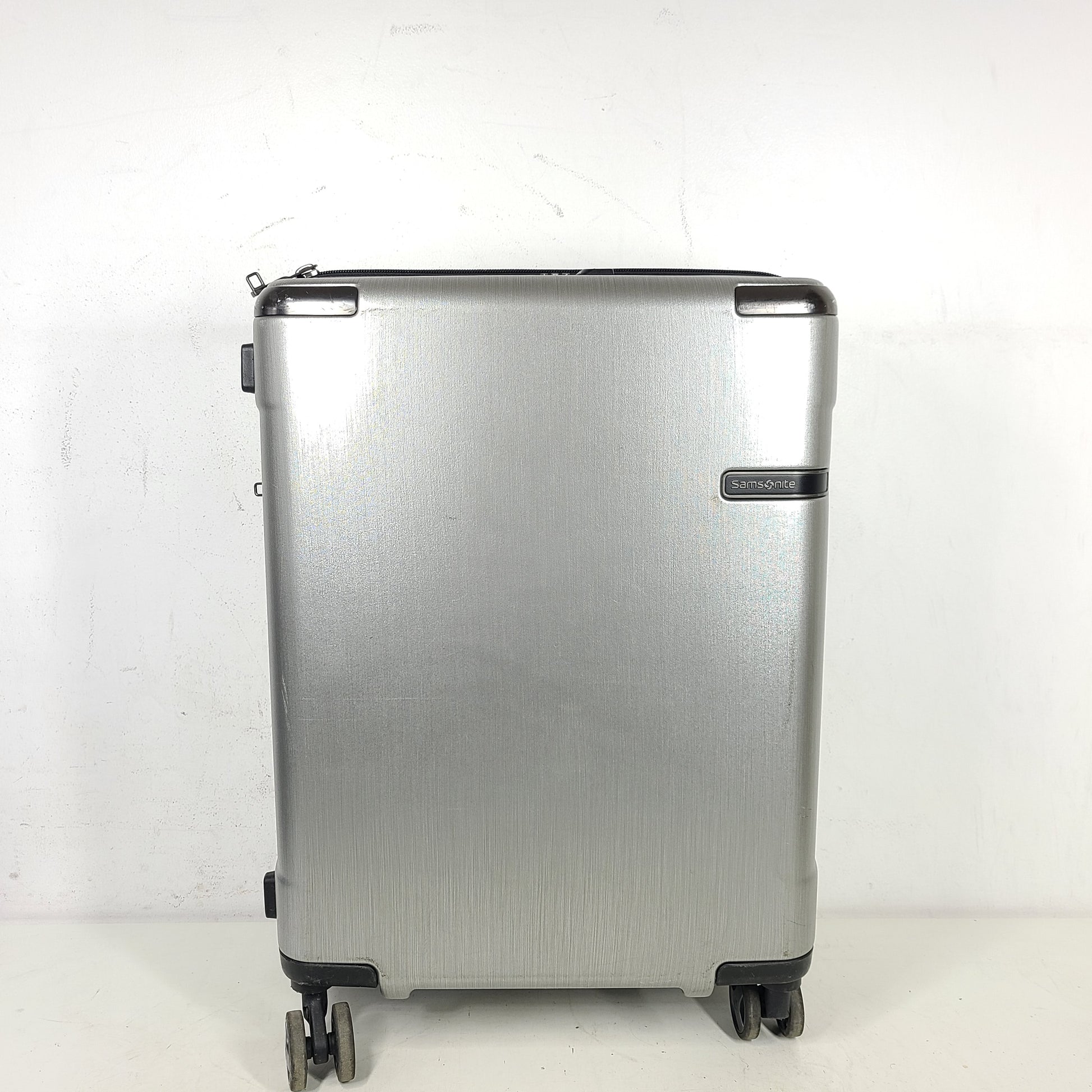 Silver Samsonite luggage with exterior branding on the handle and light exterior scratches; interior shows minimal wear.