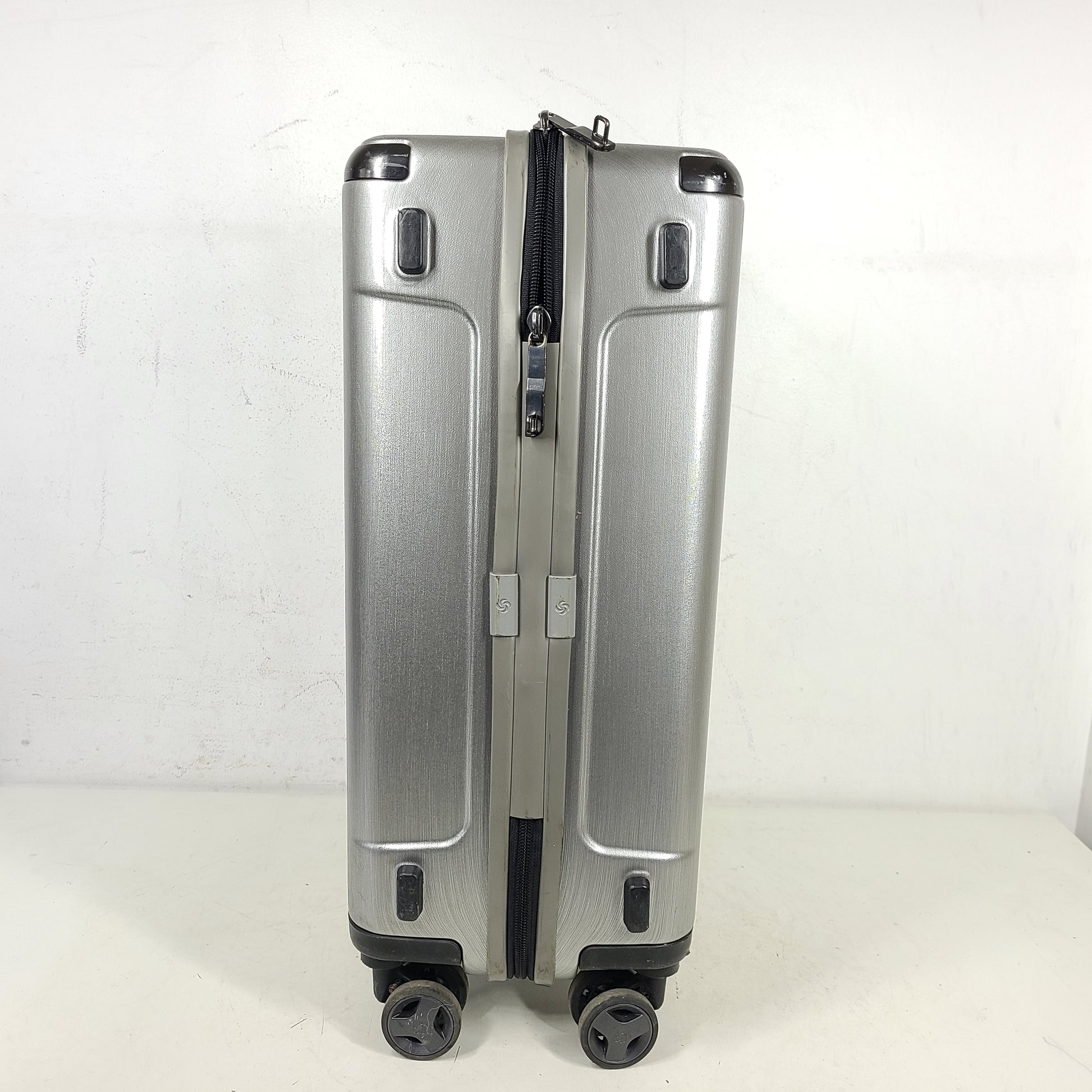 Silver Samsonite luggage with exterior branding on the handle and light exterior scratches; interior shows minimal wear.