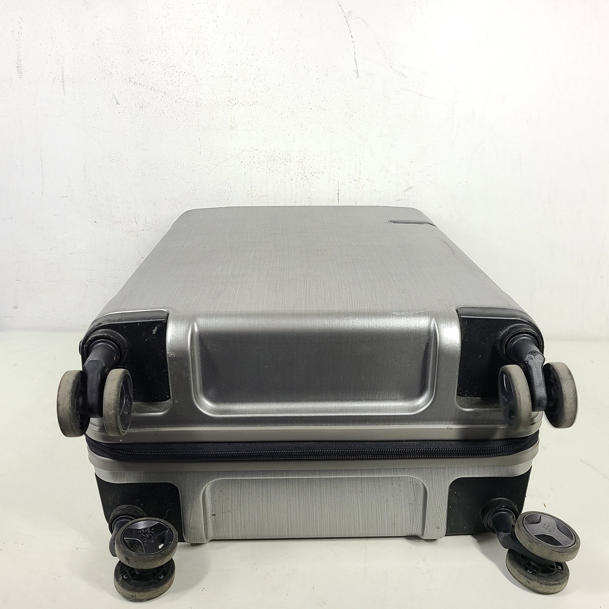Silver Samsonite luggage with exterior branding on the handle and light exterior scratches; interior shows minimal wear.