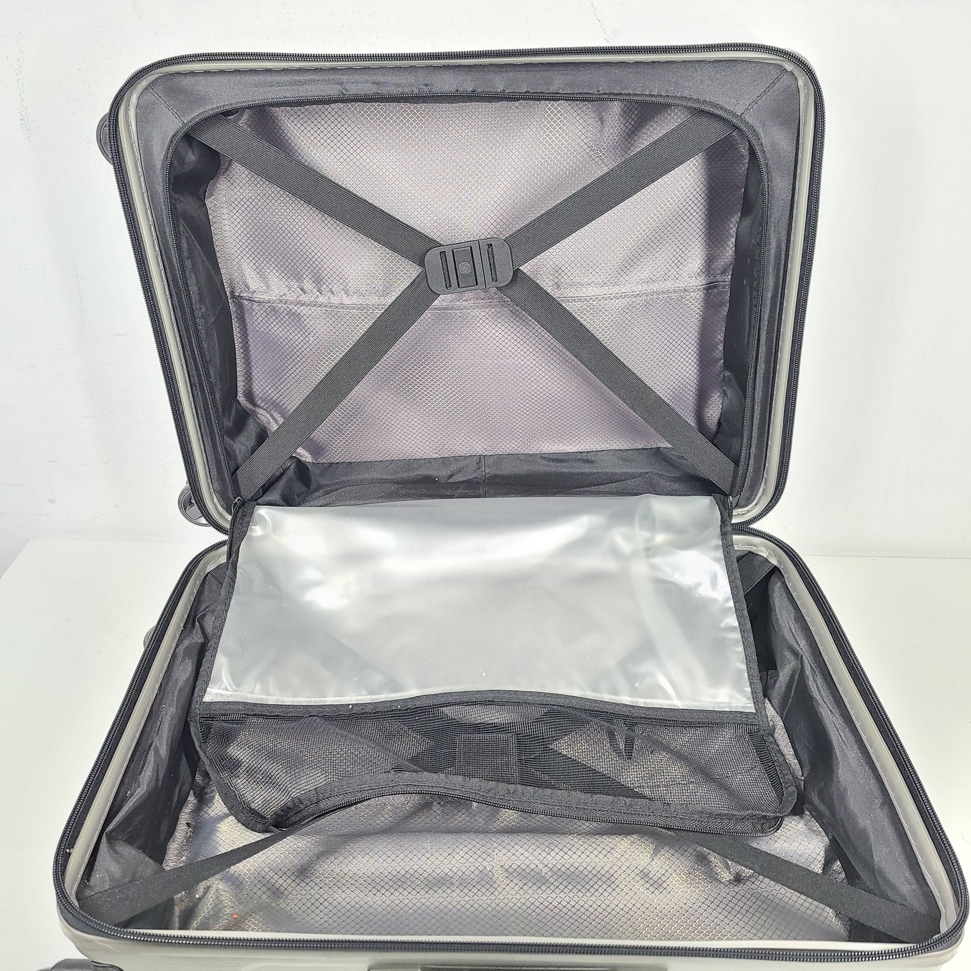 Silver Samsonite luggage with exterior branding on the handle and light exterior scratches; interior shows minimal wear.
