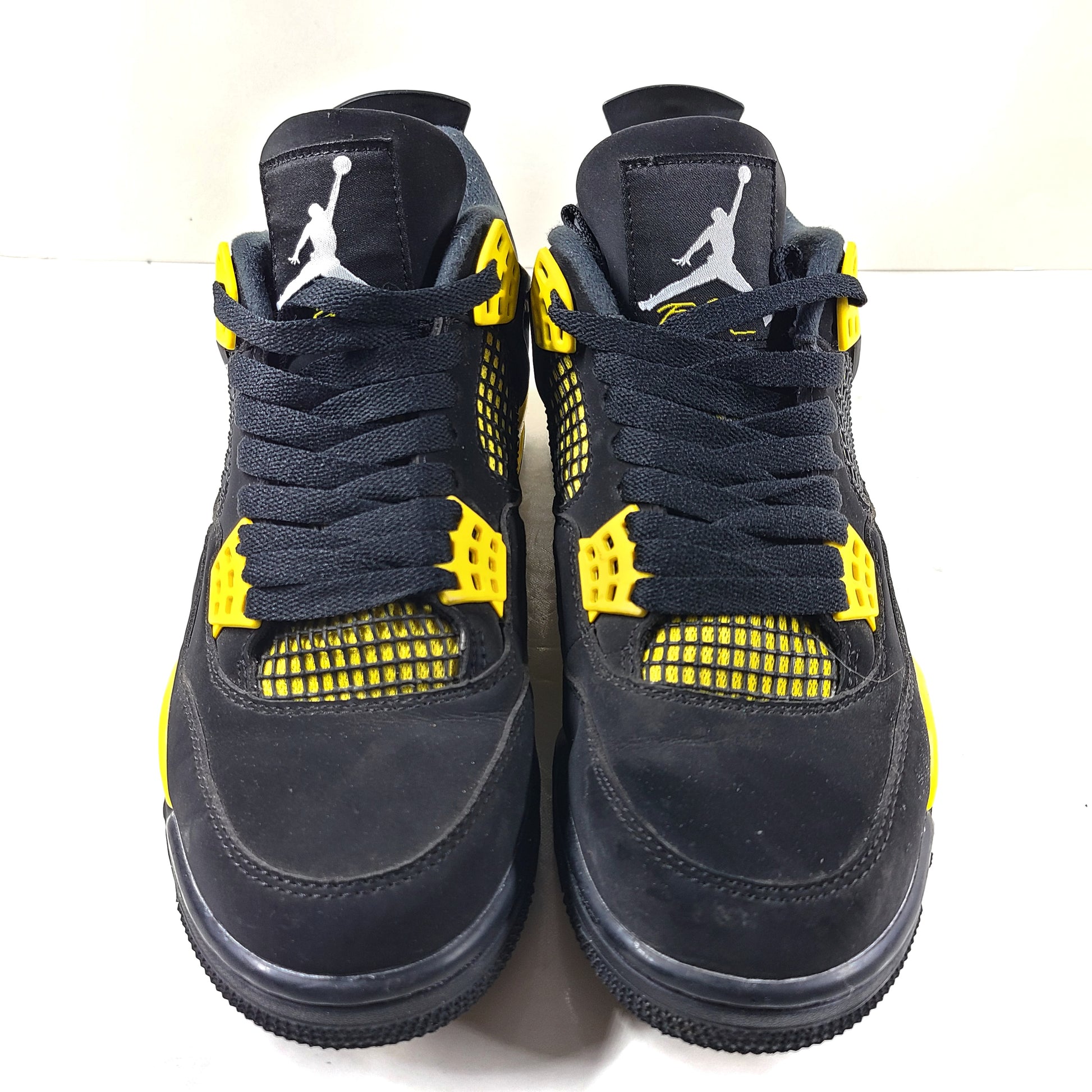 Black and yellow Air Jordan 4 Retro Thunder in US size 8 with a classic mid-top silhouette and durable rubber sole.
