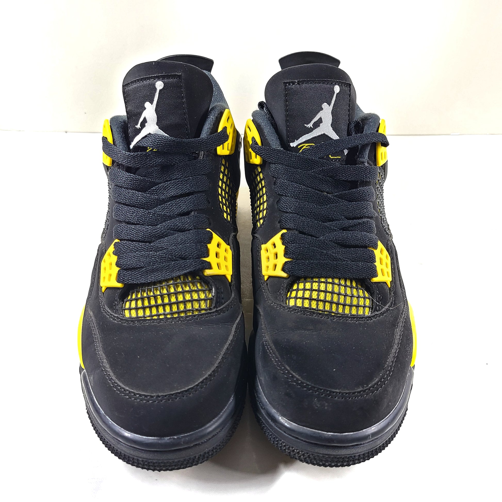 Black and yellow Air Jordan 4 Retro Thunder in US size 8 with a classic mid-top silhouette and durable rubber sole.