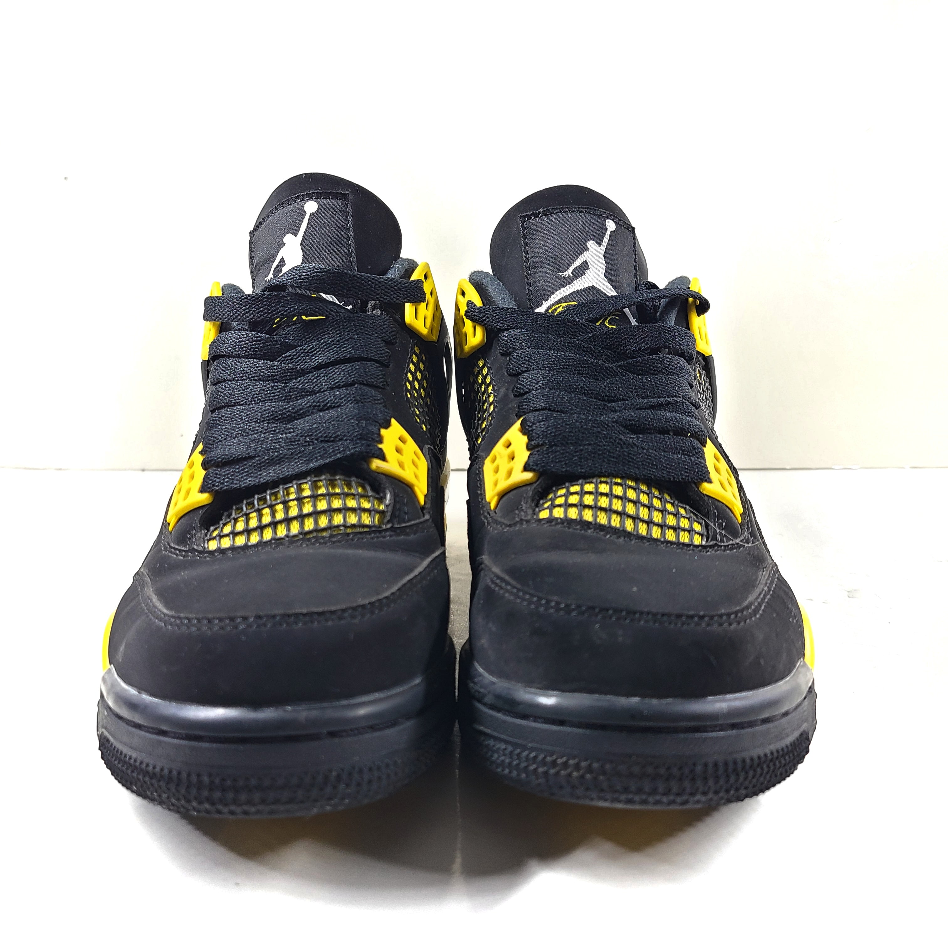 Black and yellow Air Jordan 4 Retro Thunder in US size 8 with a classic mid-top silhouette and durable rubber sole.
