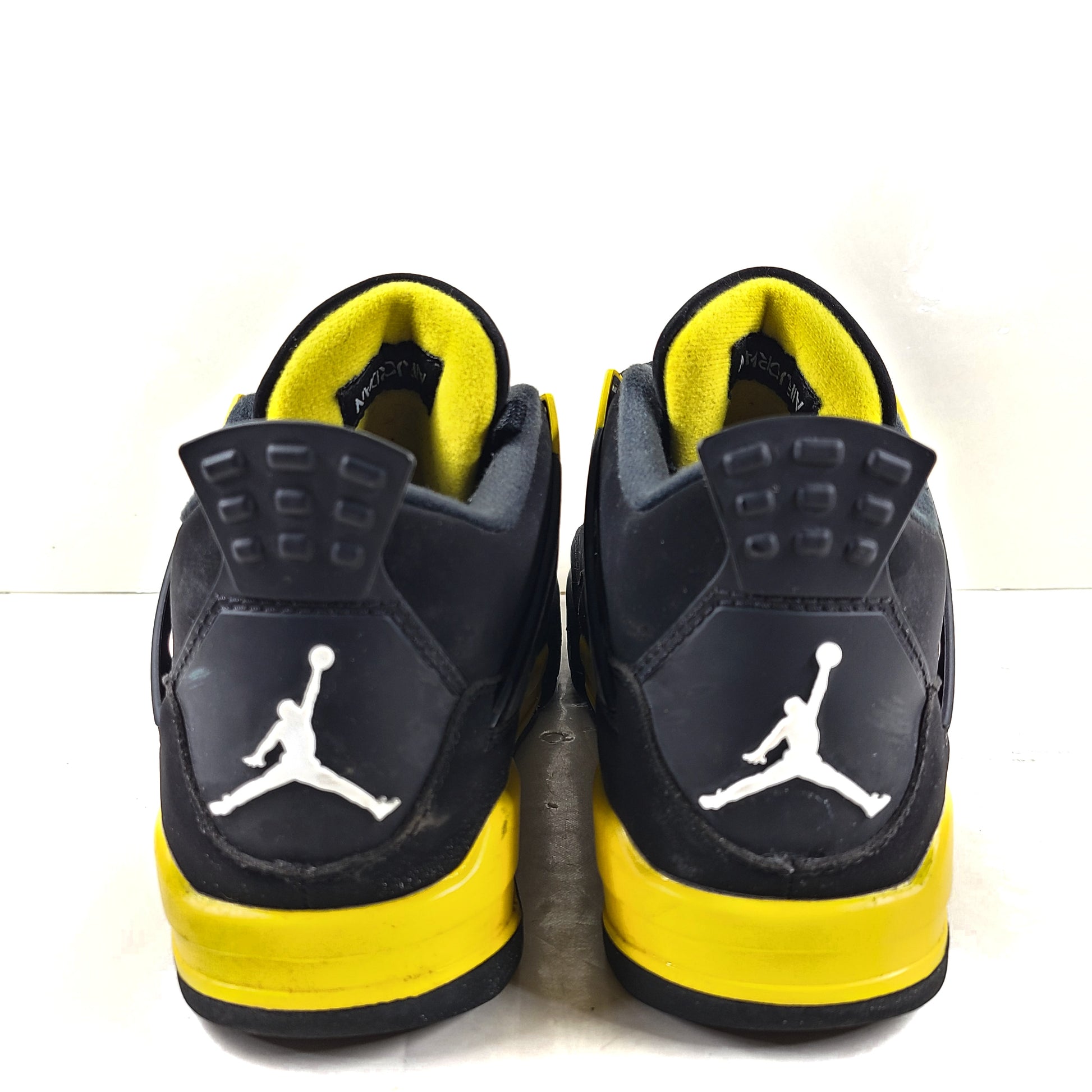 Black and yellow Air Jordan 4 Retro Thunder in US size 8 with a classic mid-top silhouette and durable rubber sole.