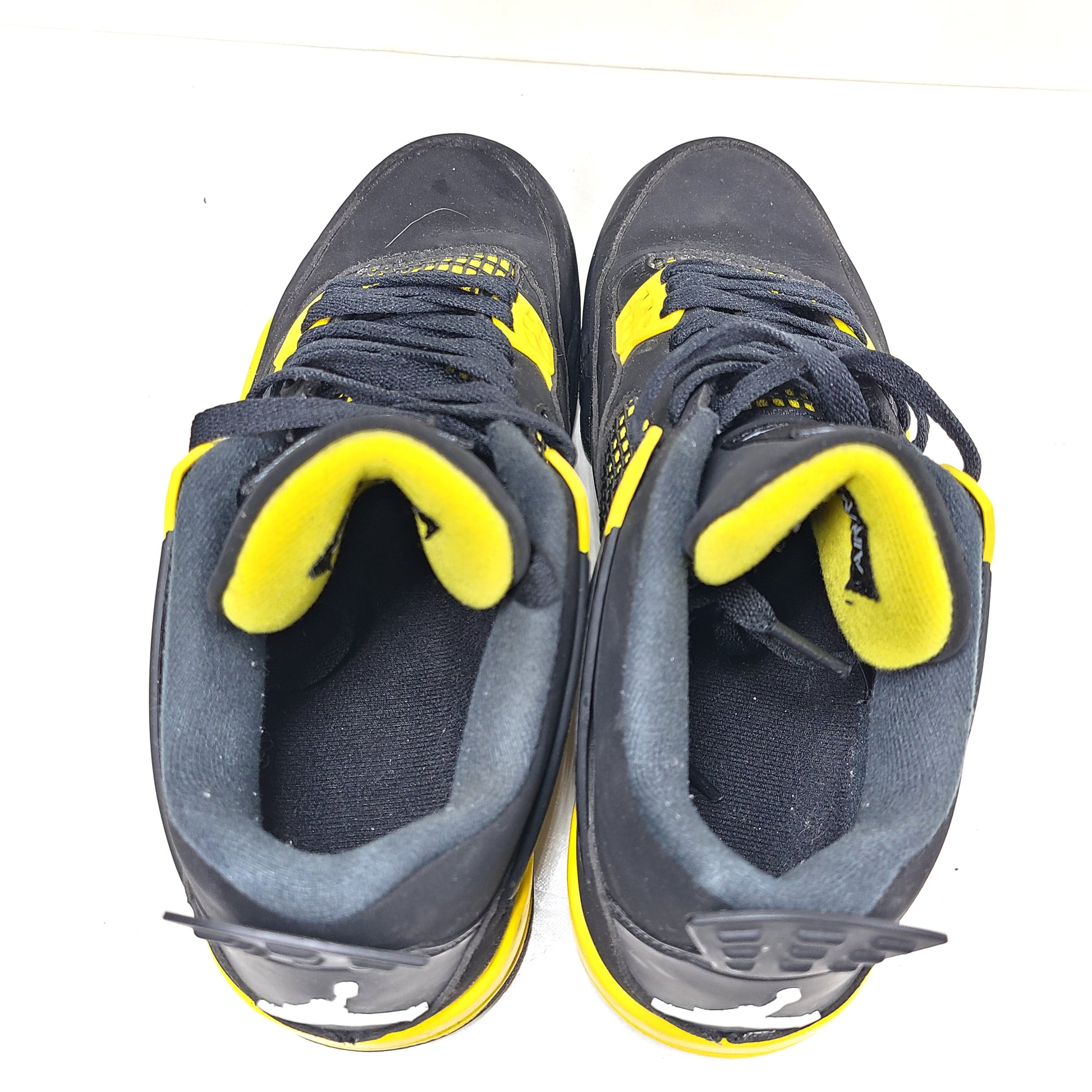 Black and yellow Air Jordan 4 Retro Thunder in US size 8 with a classic mid-top silhouette and durable rubber sole.