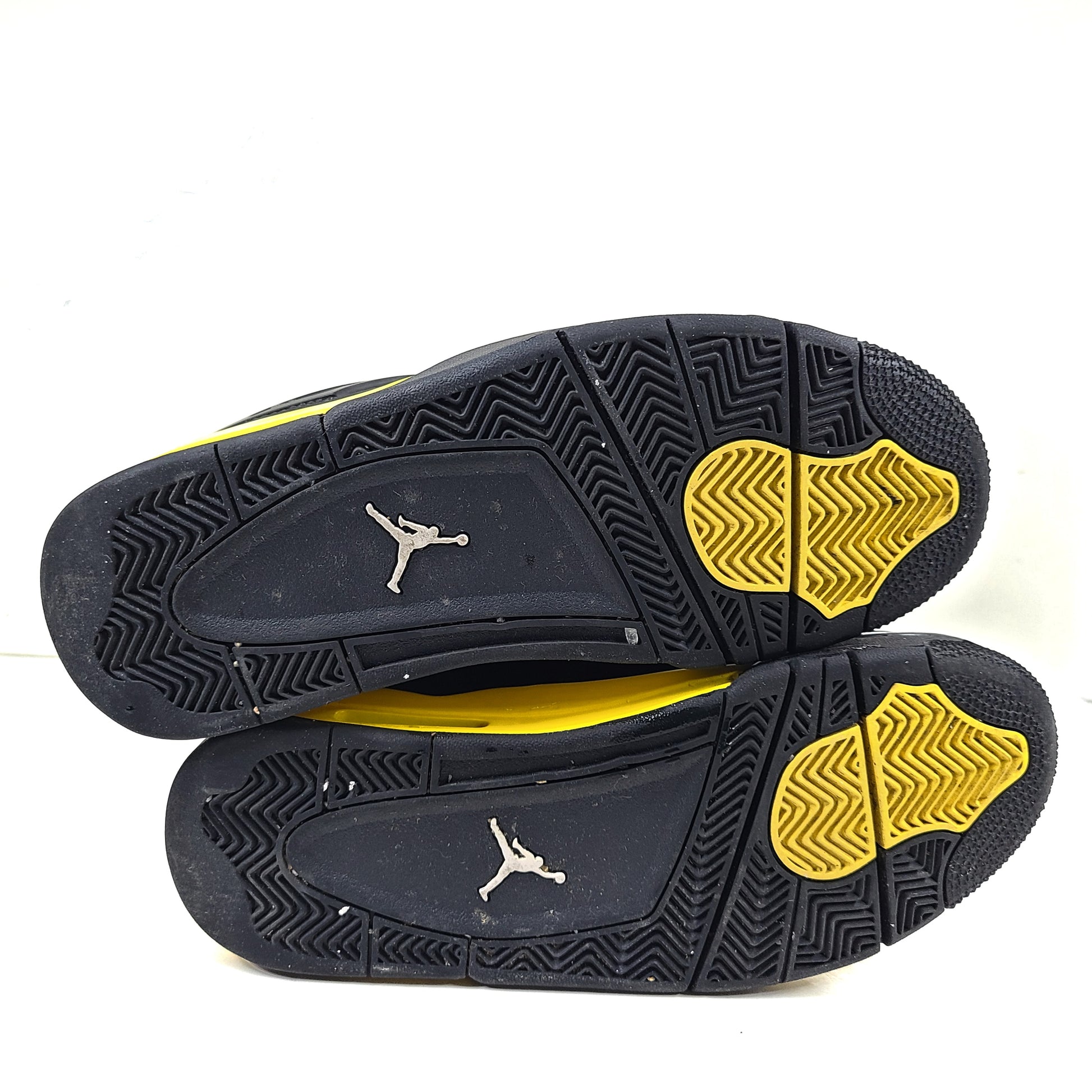 Black and yellow Air Jordan 4 Retro Thunder in US size 8 with a classic mid-top silhouette and durable rubber sole.