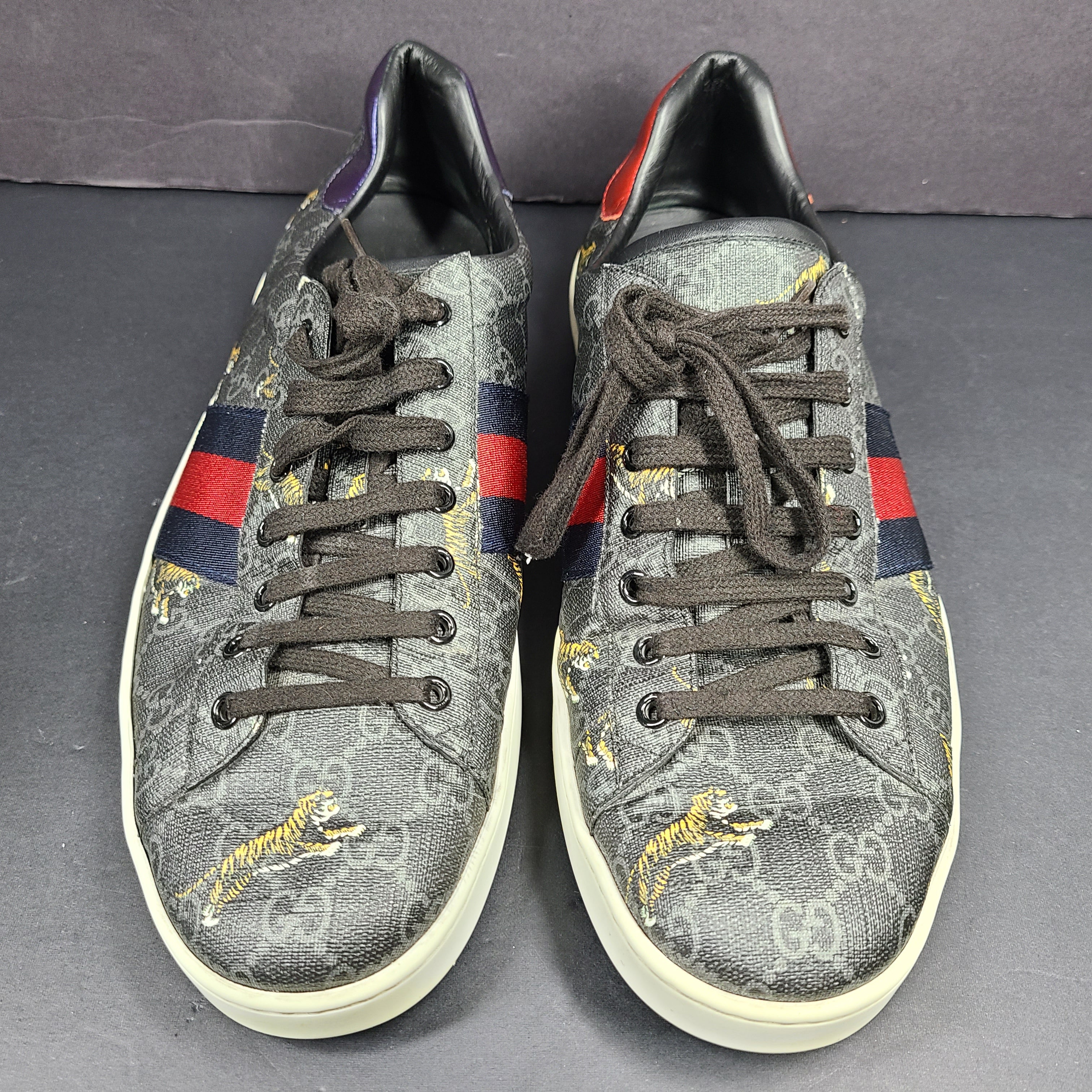 Gucci Ace GG Supreme Tiger sneaker in black with red and blue web stripes and purple and red accents.