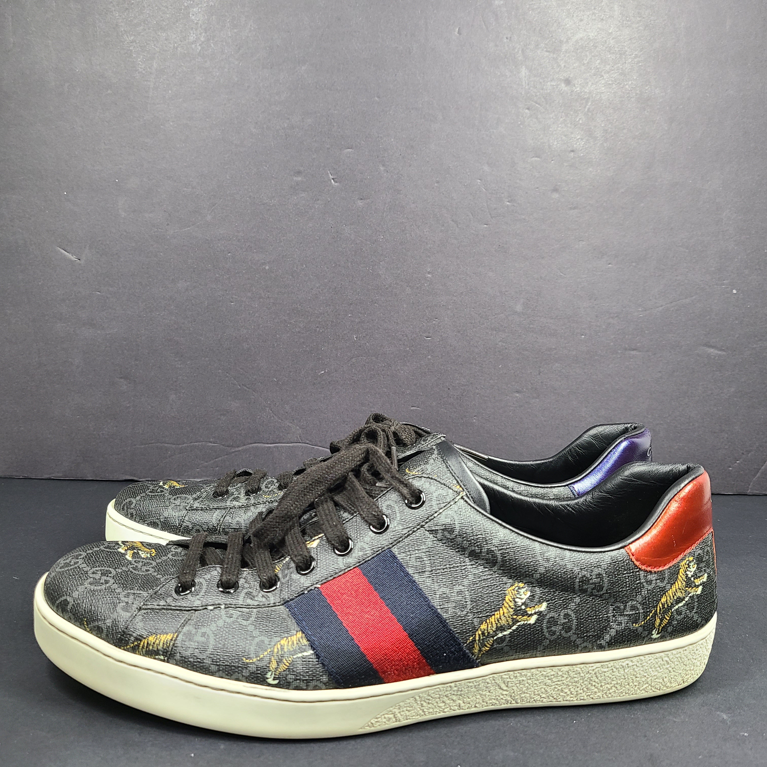 Gucci Ace GG Supreme Tiger sneaker in black with red and blue web stripes and purple and red accents.