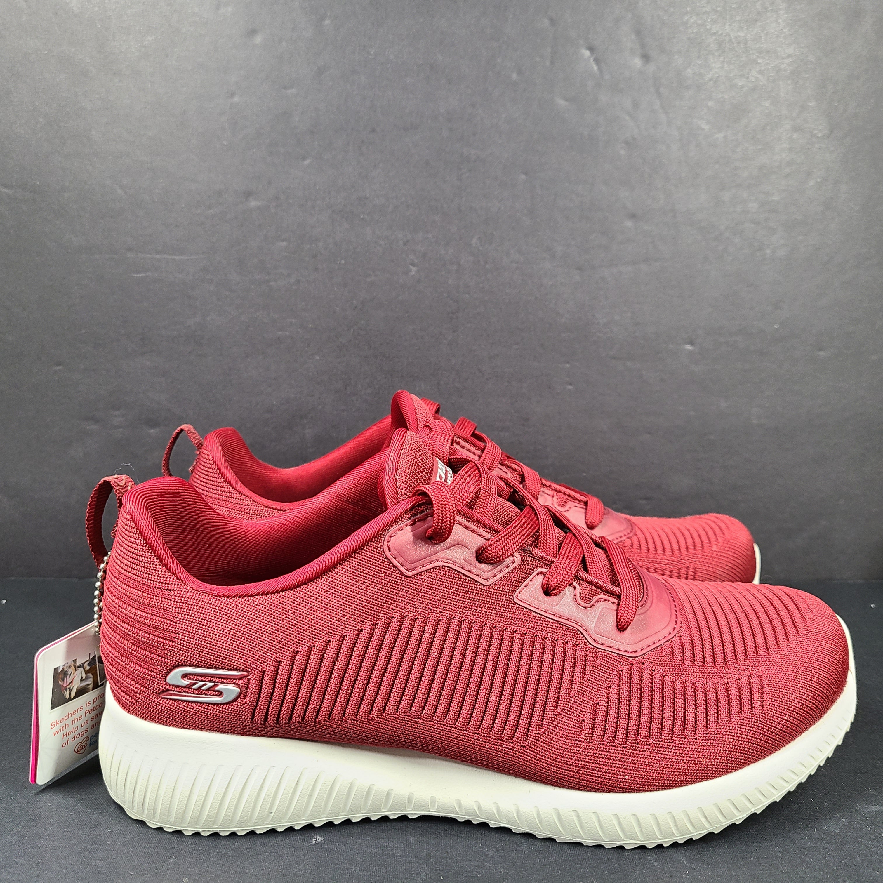 Red Skechers BOBS women's sneaker with cushioned memory foam insole and knit upper for everyday comfort.