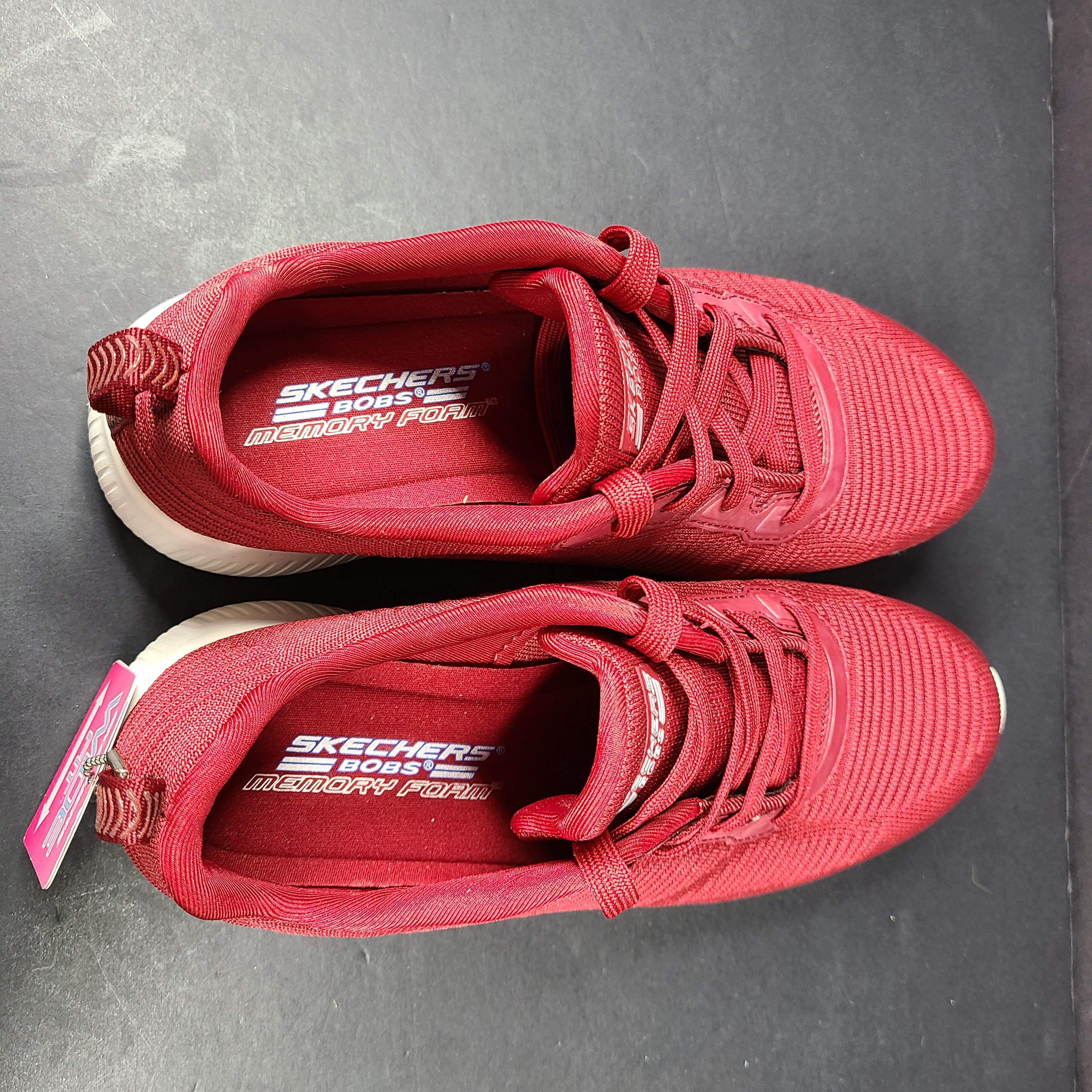 Red Skechers BOBS women's sneaker with cushioned memory foam insole and knit upper for everyday comfort.