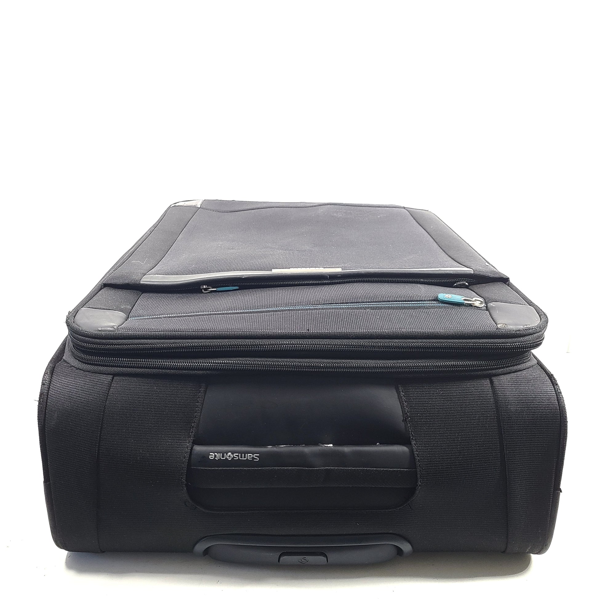 Black Samsonite 67/24 EXP spinner suitcase with scuffs and marks on the exterior.
