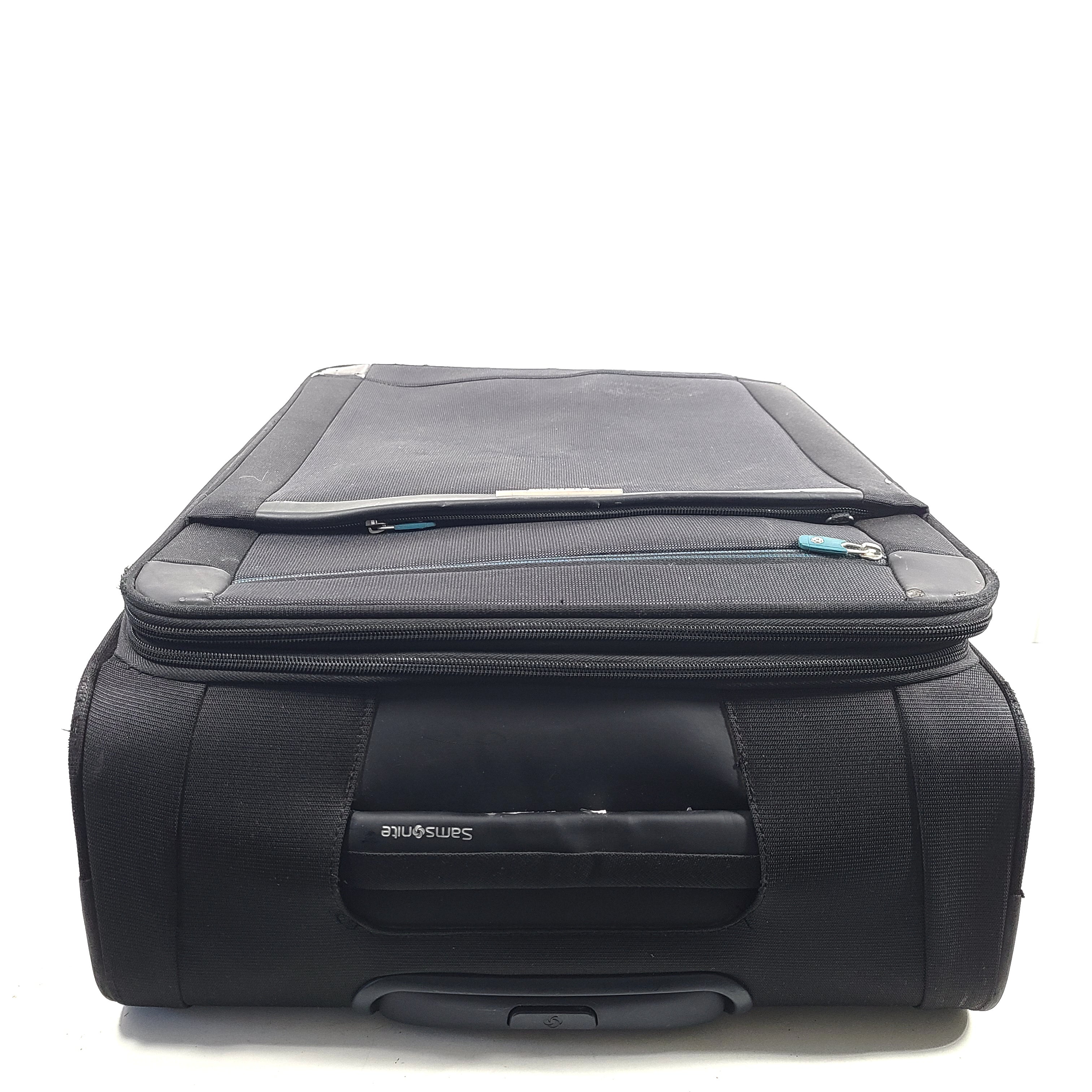 Black Samsonite 67/24 EXP spinner suitcase with scuffs and marks on the exterior.