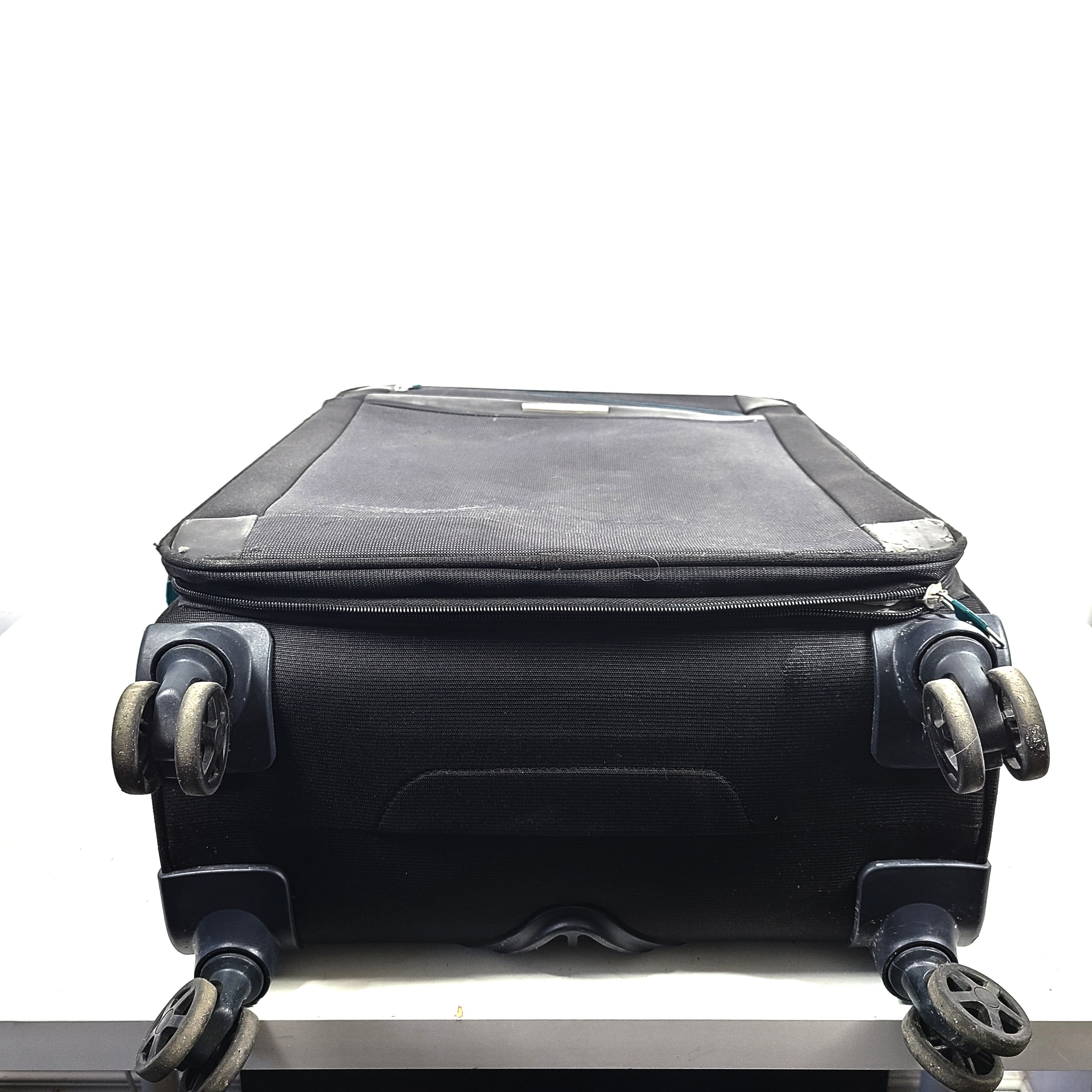 Black Samsonite 67/24 EXP spinner suitcase with scuffs and marks on the exterior.