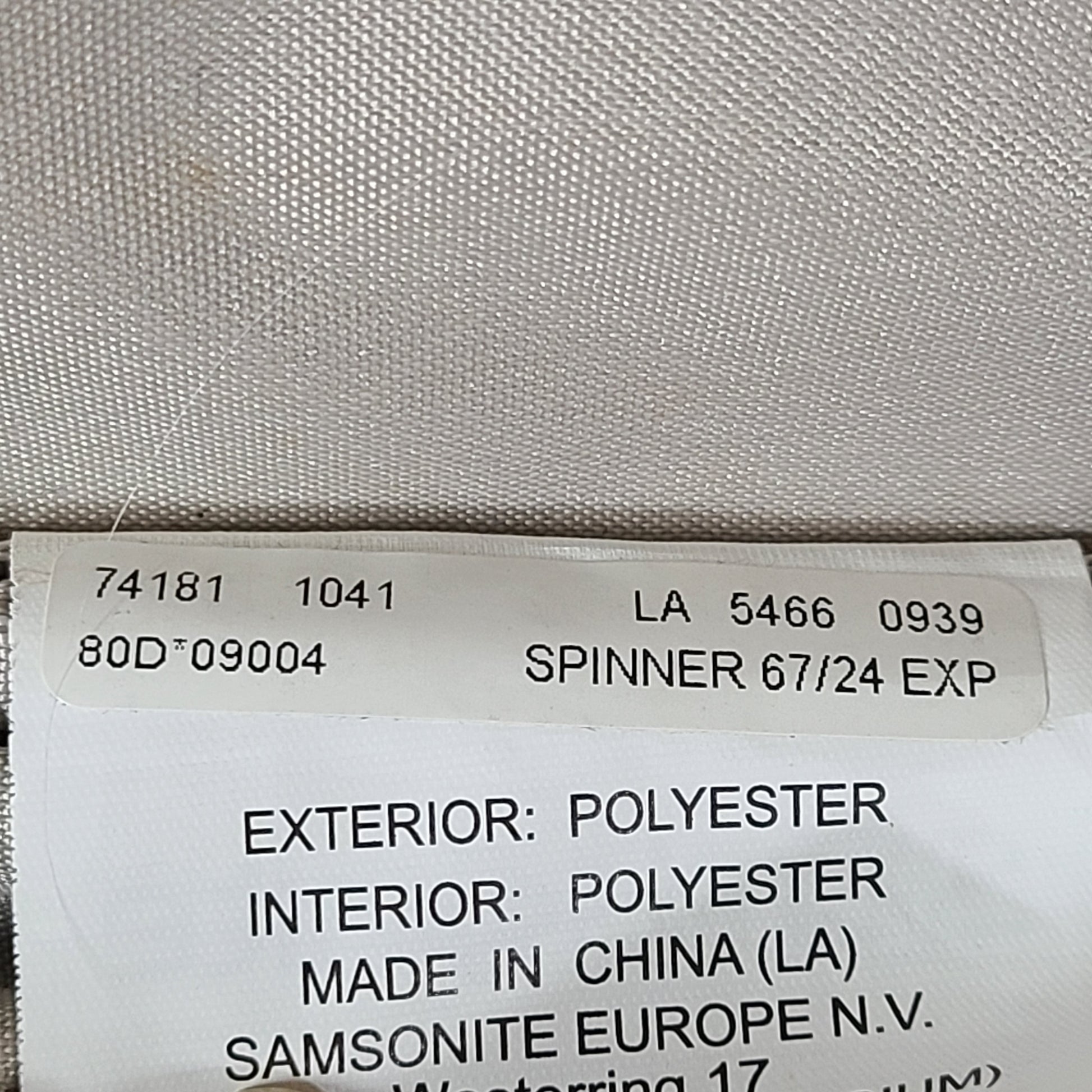 Black Samsonite 67/24 EXP spinner suitcase with scuffs and marks on the exterior.