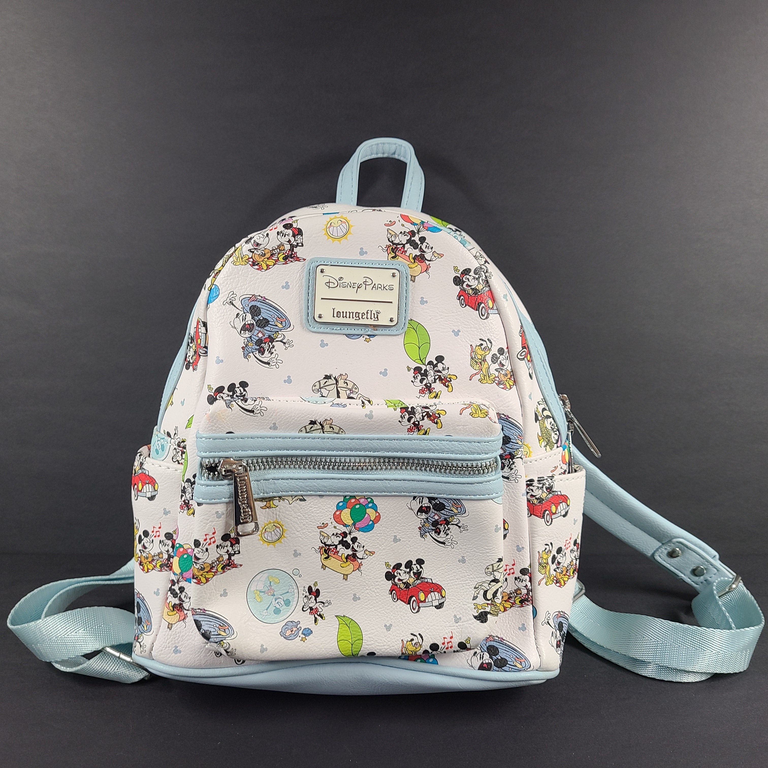 Light blue Loungefly Disney Parks mini backpack with multicolor print and Disney Parks and Loungefly labels.
