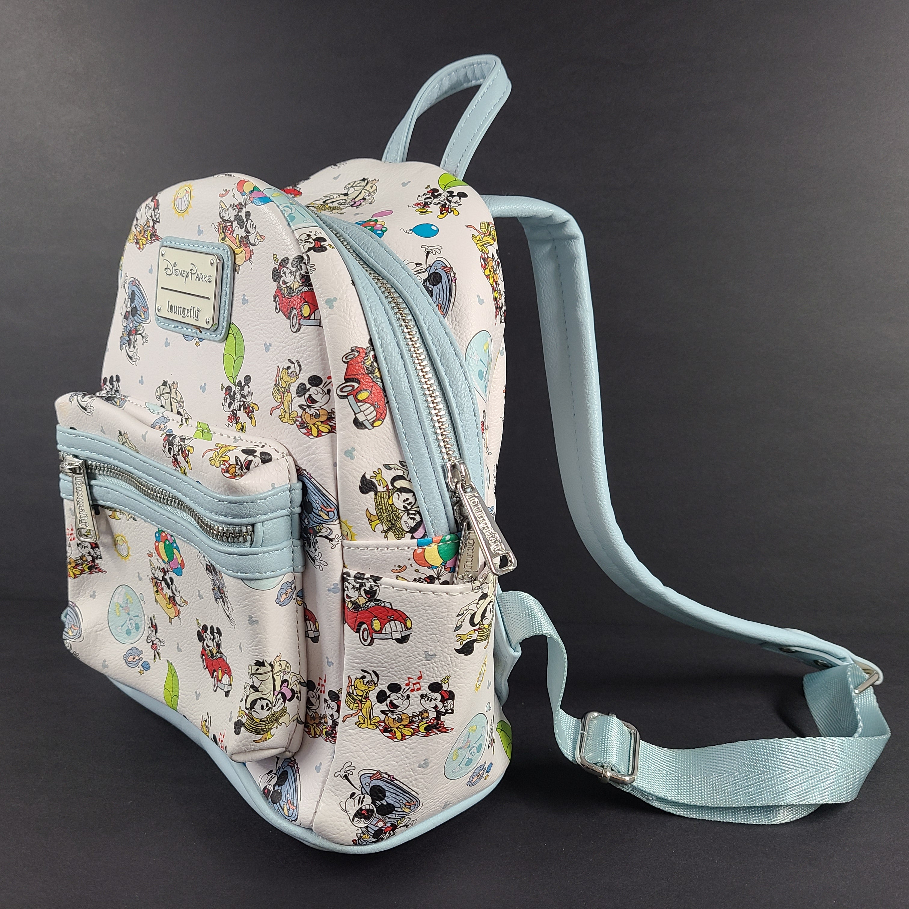Light blue Loungefly Disney Parks mini backpack with multicolor print and Disney Parks and Loungefly labels.