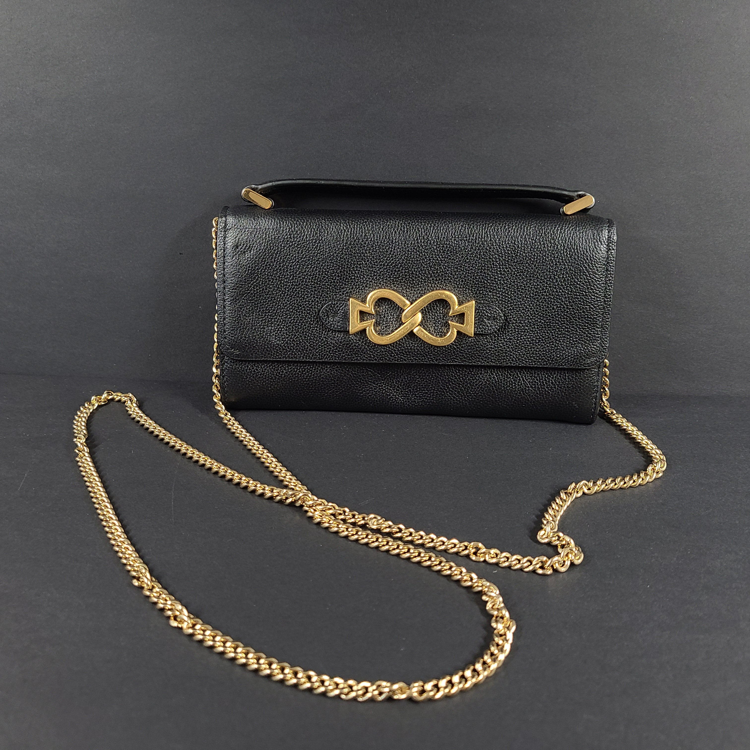 Black Kate Spade leather crossbody handbag with gold chain strap and branded logo.