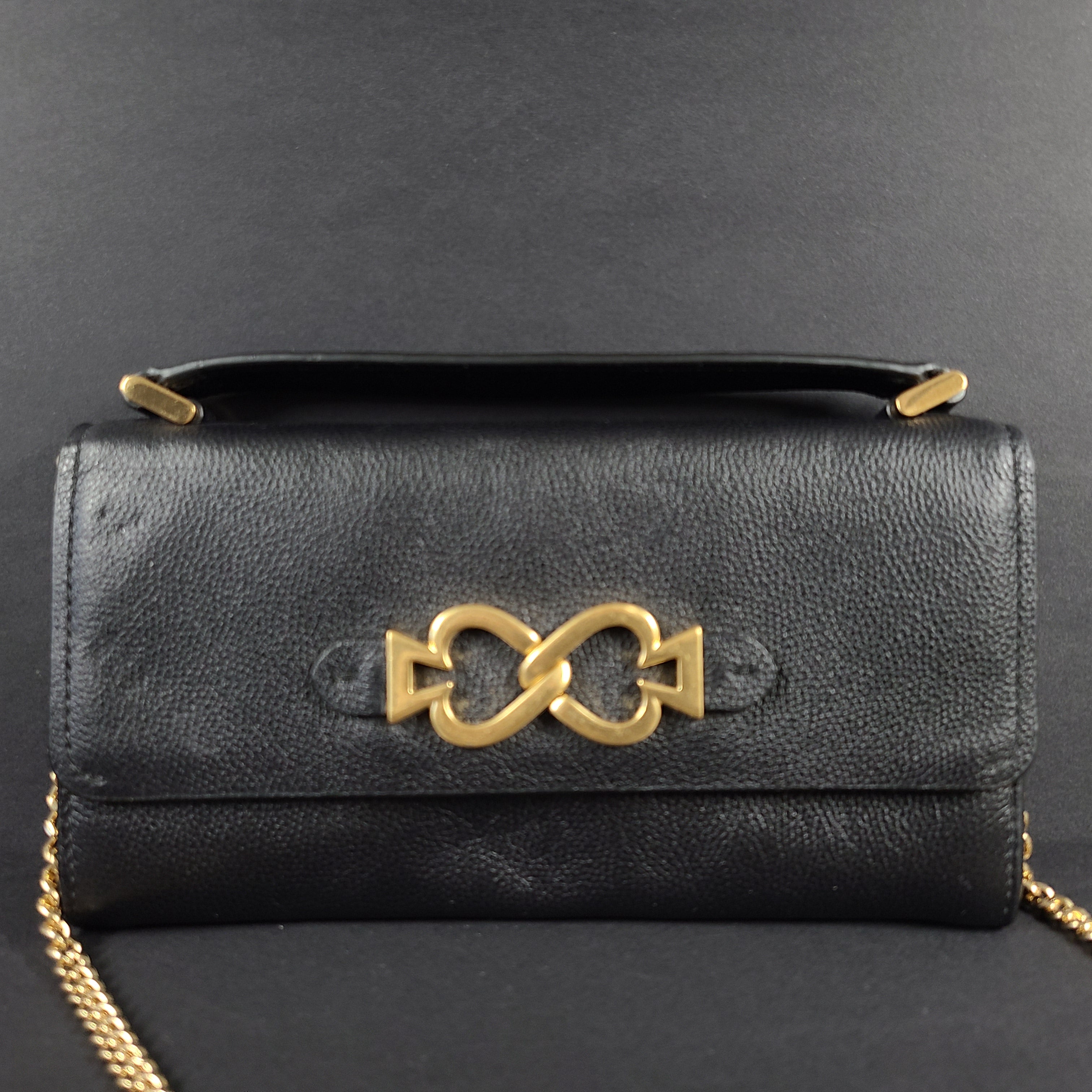 Black Kate Spade leather crossbody handbag with gold chain strap and branded logo.