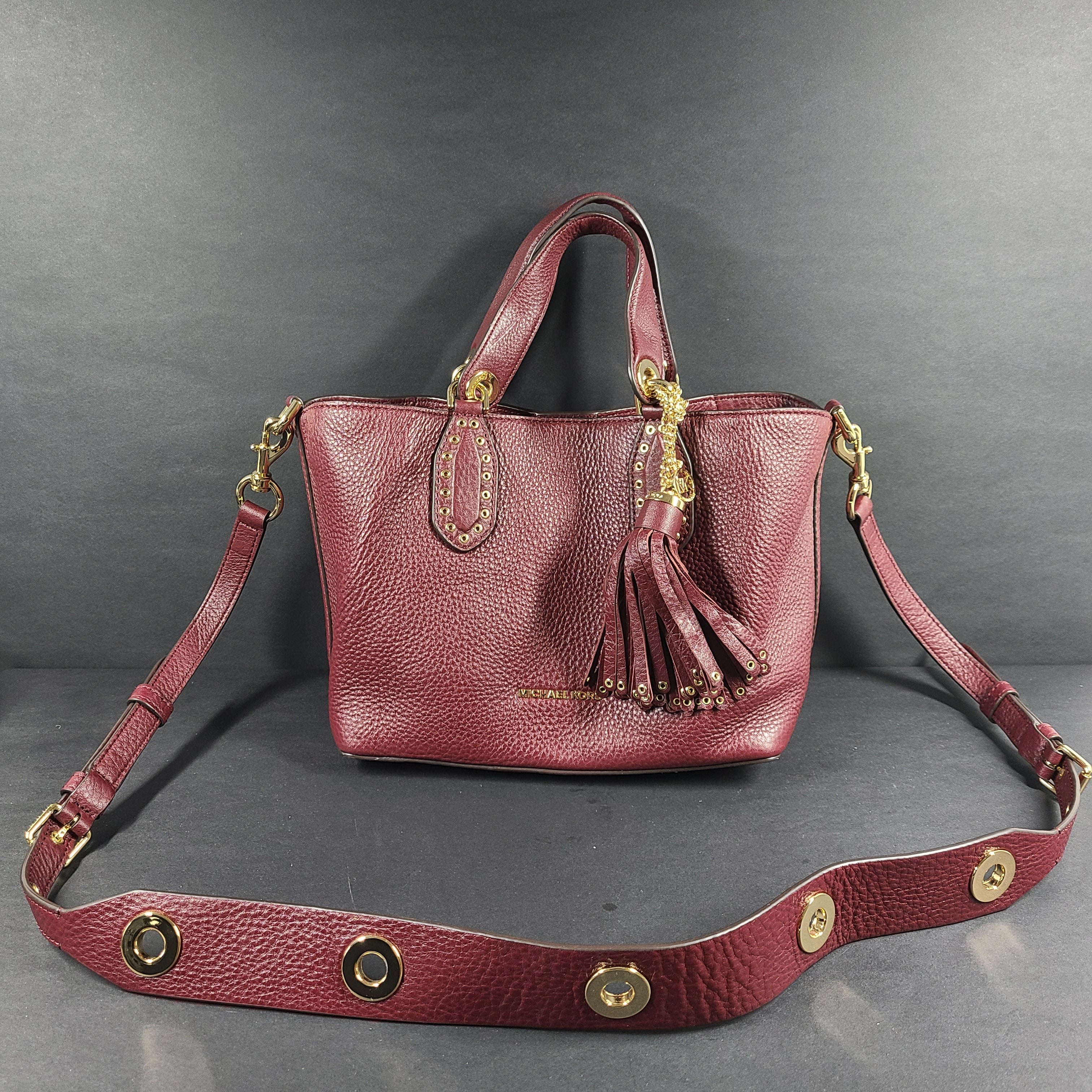 A compact leather Michael Kors Brooklyn SM grab bag in oxblood with gold-tone hardware and a detachable strap.