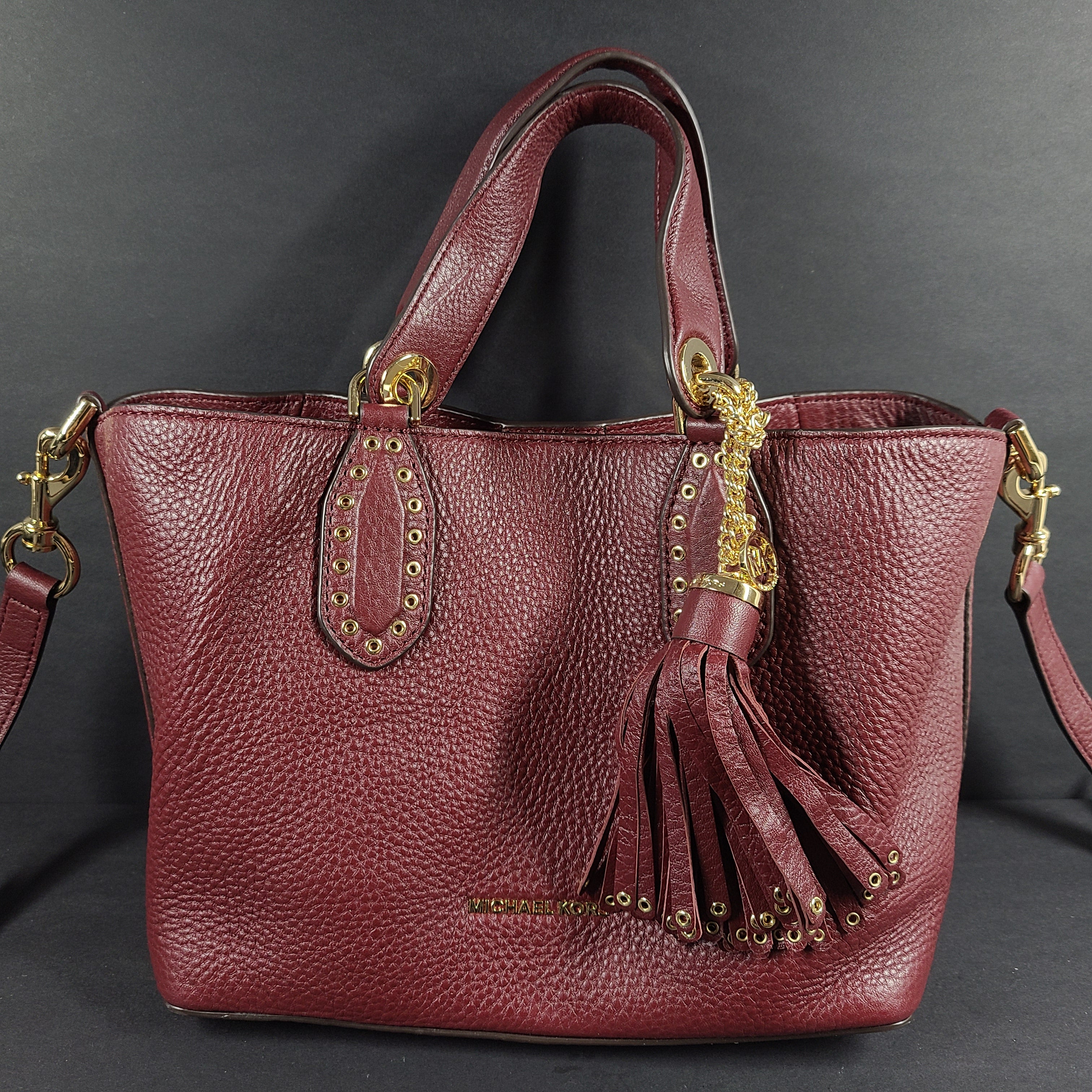 A compact leather Michael Kors Brooklyn SM grab bag in oxblood with gold-tone hardware and a detachable strap.