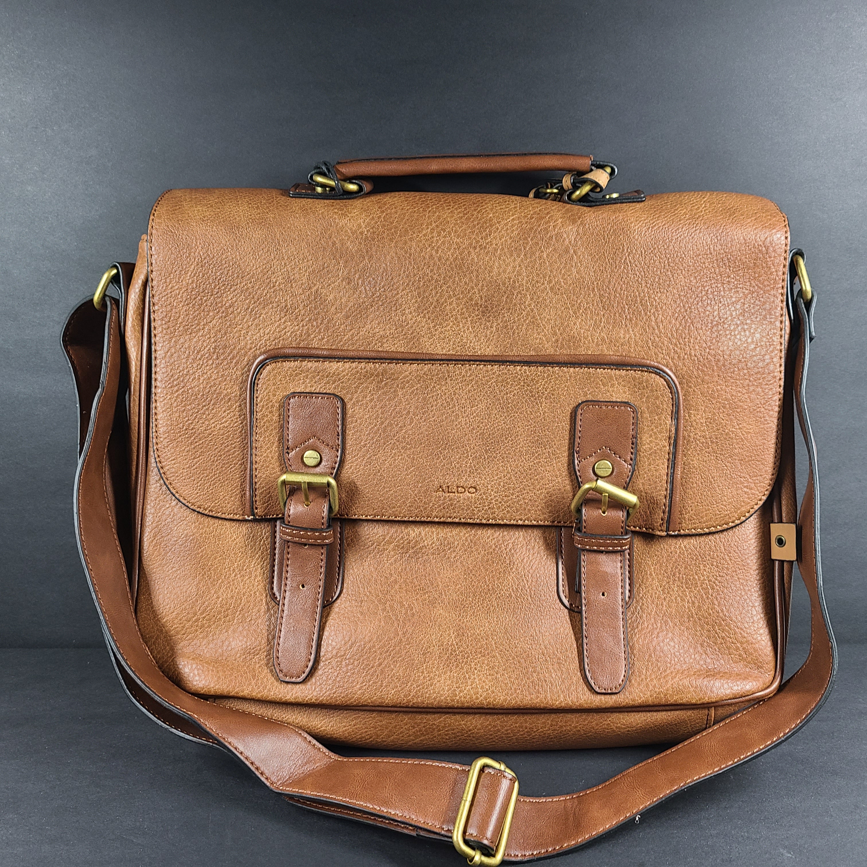Brown ALDO messenger bag with adjustable strap and luggage tag designed to carry up to a 15-inch laptop.