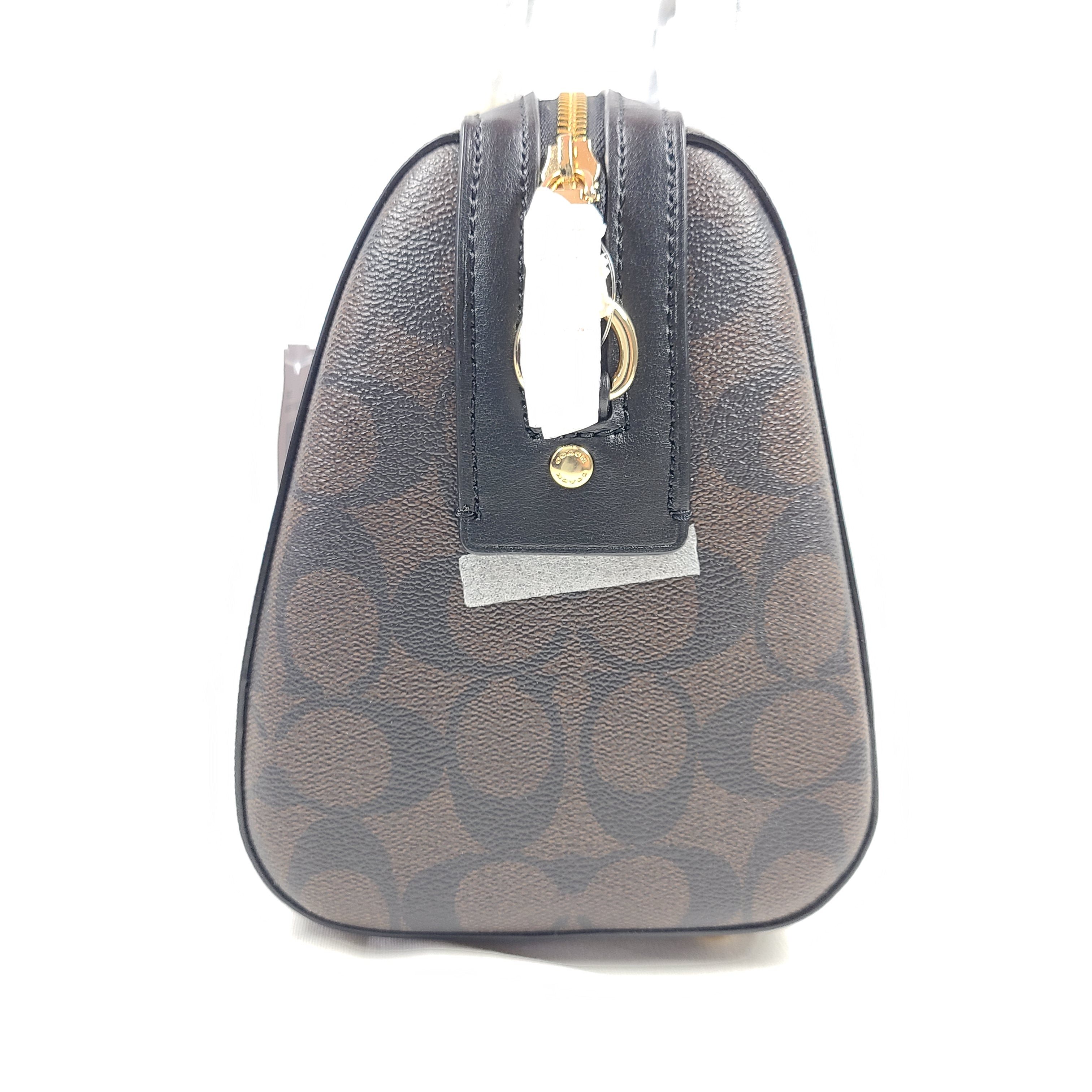 Coach brown signature-print handbag with black accents, including an interior label with the model number.