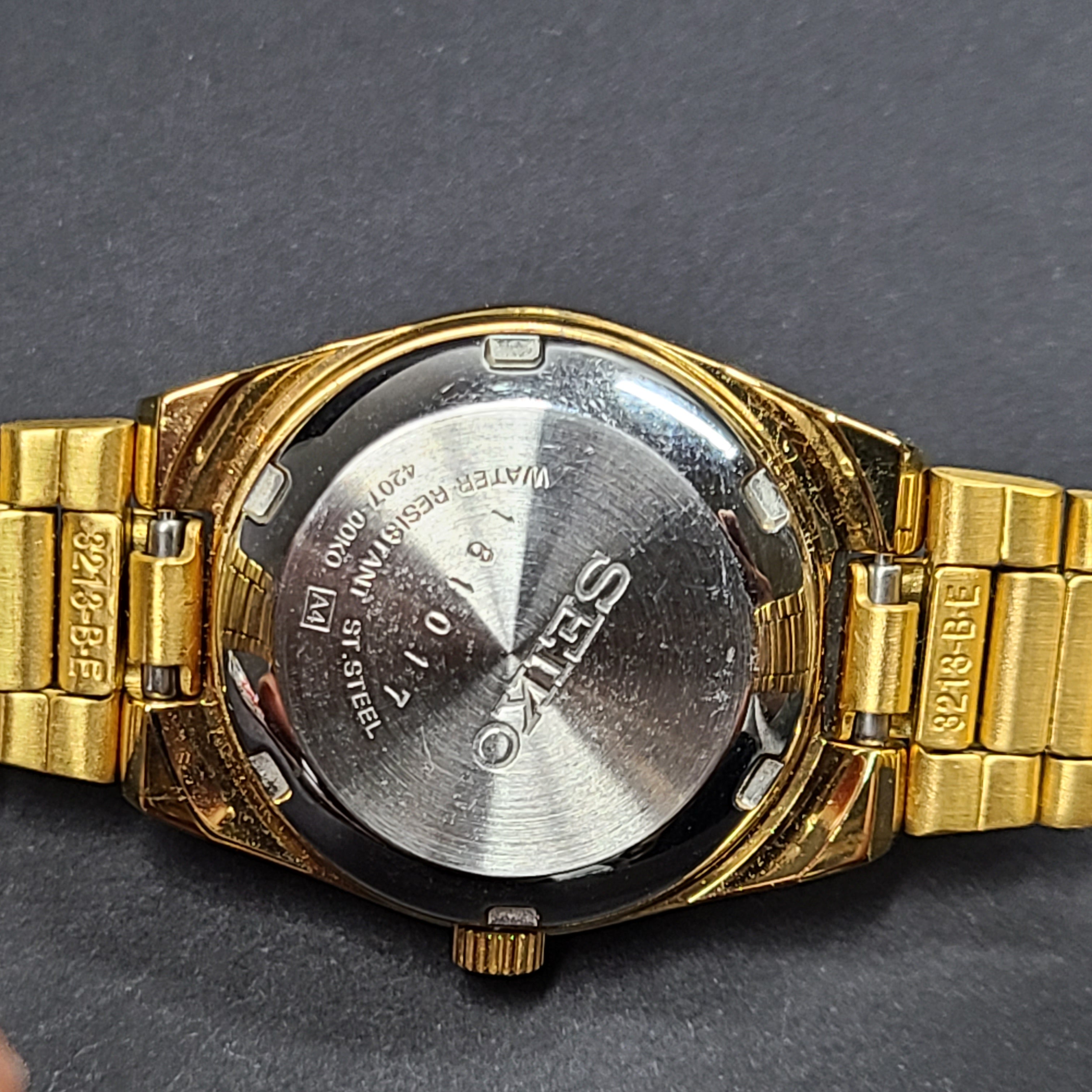 Gold-tone Seiko 5 automatic ladies watch with a black dial and stainless steel bracelet.